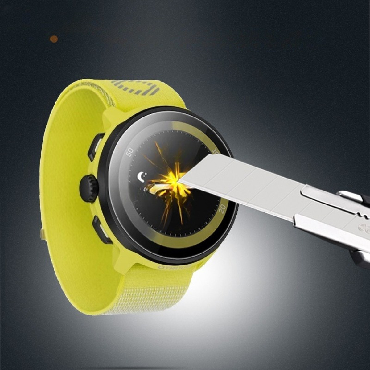Uno smartwatch giallo con schermo nero viene testato con un taglierino. L'orologio ha un cinturino giallo.