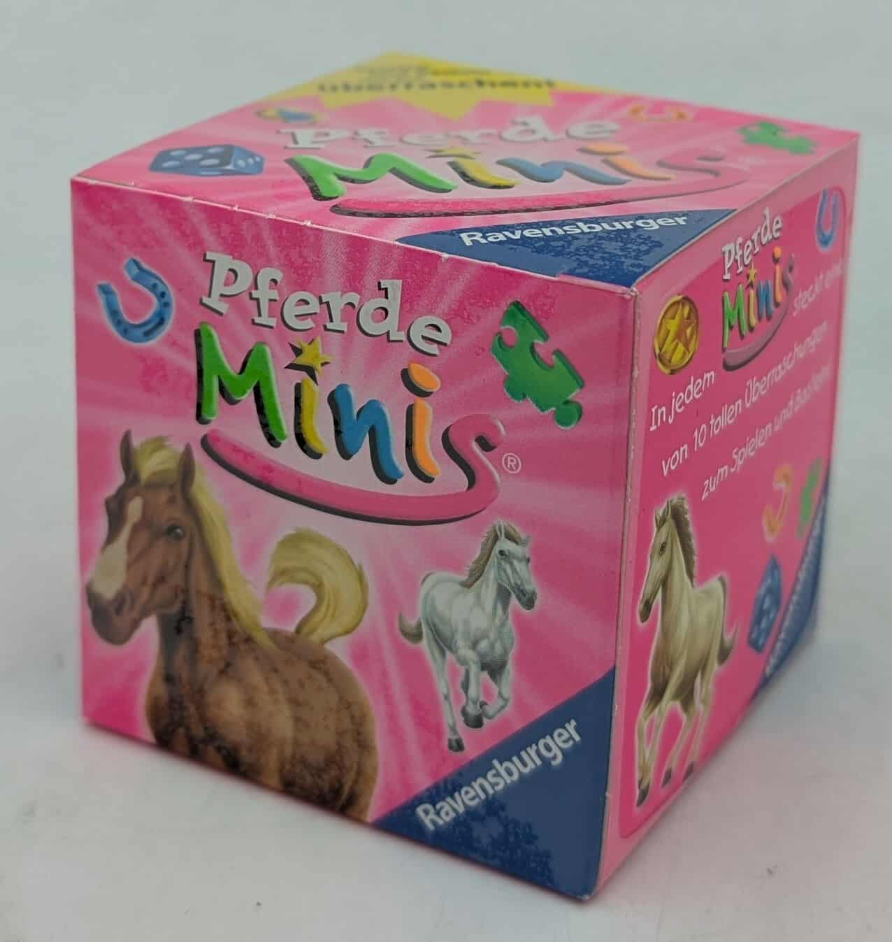 Eine rosa Schachtel mit 'Pferde Minis' und Pferdeillustrationen. Der Markenname 'Ravensburger' ist sichtbar.