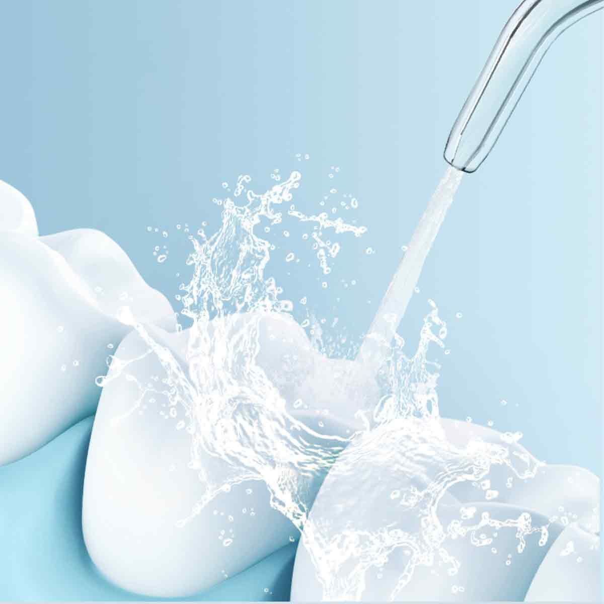Wasserstrahl reinigt Zähne. Weiße Zähne mit Wasserspritzern. Blauer Hintergrund. Konzept der Zahnhygiene.
