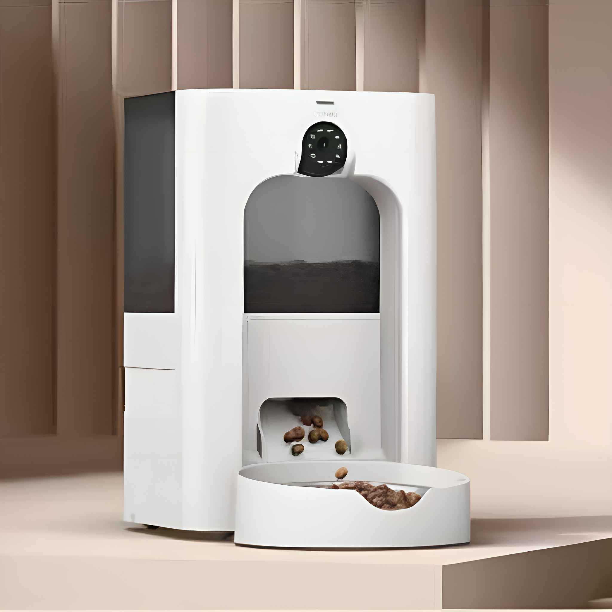 Ein weißer automatischer Futterautomat gibt Trockenfutter in eine Schüssel ab. Der Futterautomat steht auf einer beigen Oberfläche vor einer beigen Wand.