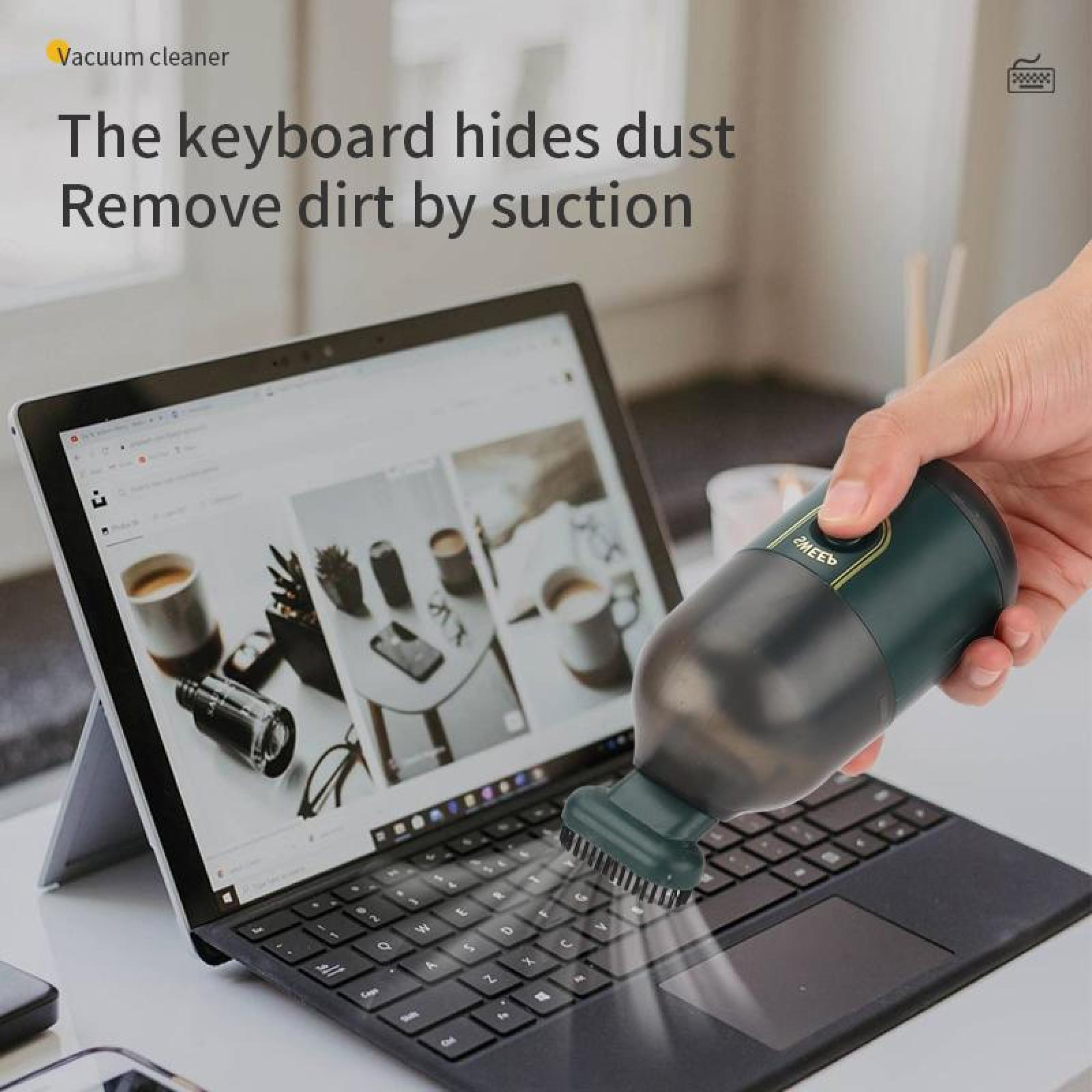 Eine Person reinigt mit einem kleinen, tragbaren Staubsauger eine Laptop-Tastatur. Der Staubsauger ist dunkelgrün und schwarz.