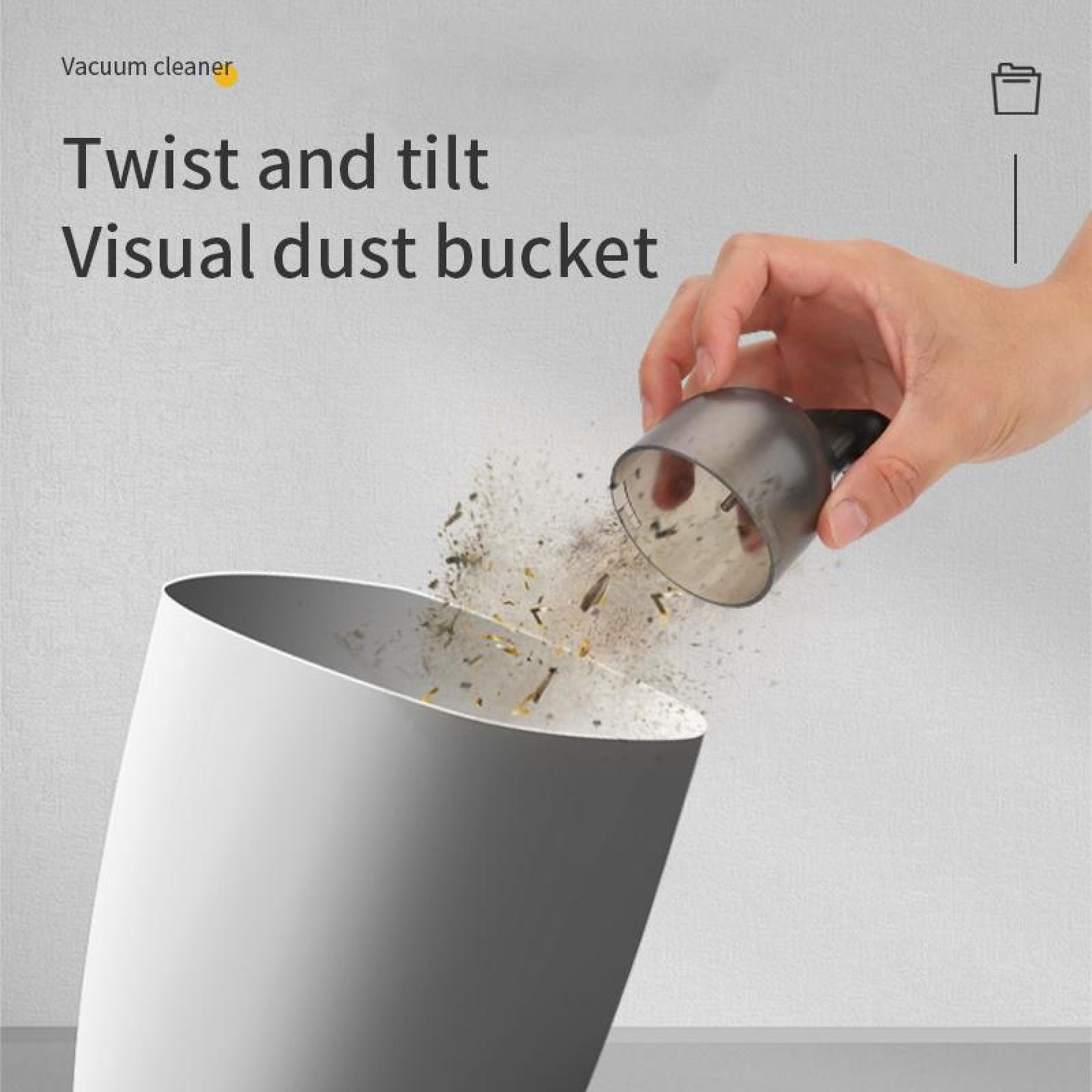 Eine Hand leert Staub aus einem Staubsauger in einen weißen Behälter. Staubpartikel sind sichtbar. Der Text lautet 'Twist and tilt'.