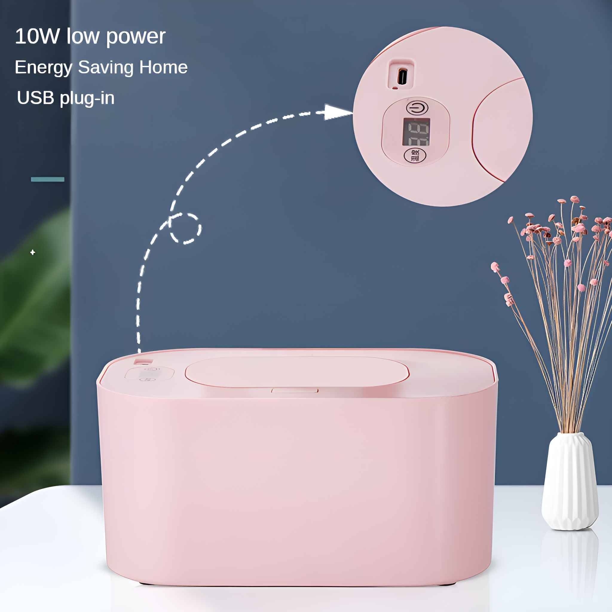 Rosa Box mit rundem Oberteil und Display, neben einer Vase mit Trockenblumen. Blauer Hintergrund und weißer Tisch.