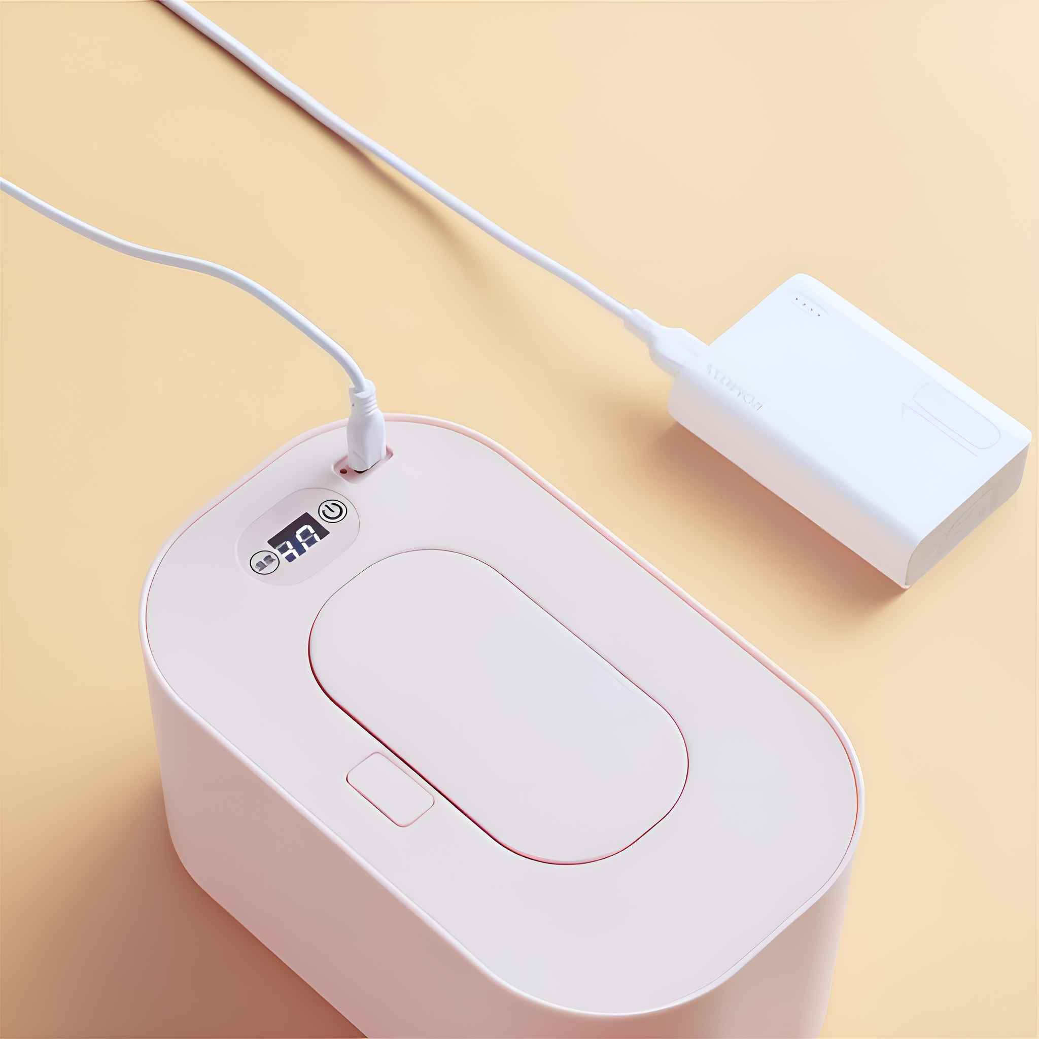 Ein rosa Gerät ist mit einer weißen Powerbank über ein weißes Kabel verbunden. Das Gerät hat ein Display.