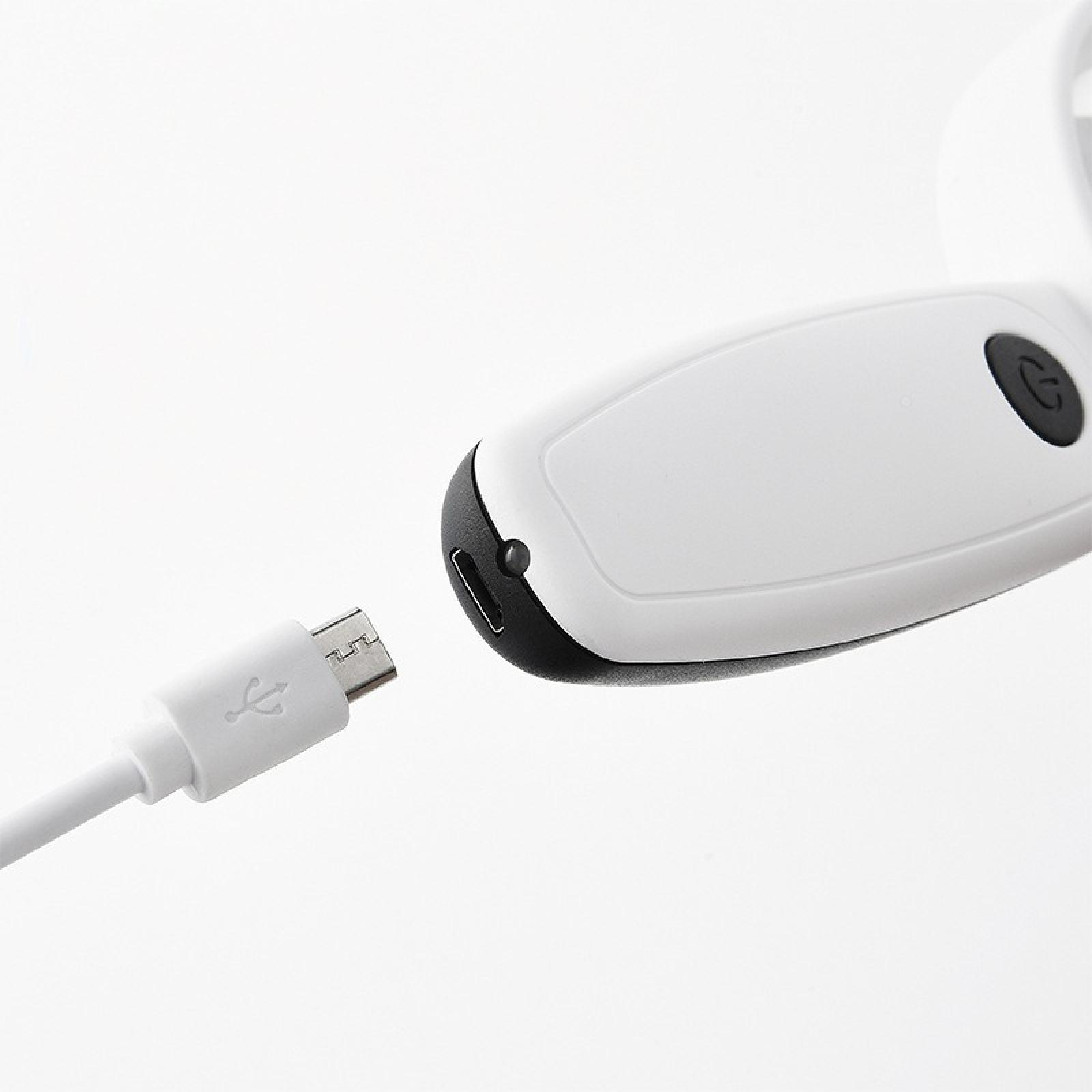 Ein weißes Gerät mit schwarzem Rand und ein weißes USB-Kabel. Das USB-Kabel nähert sich dem Gerät.