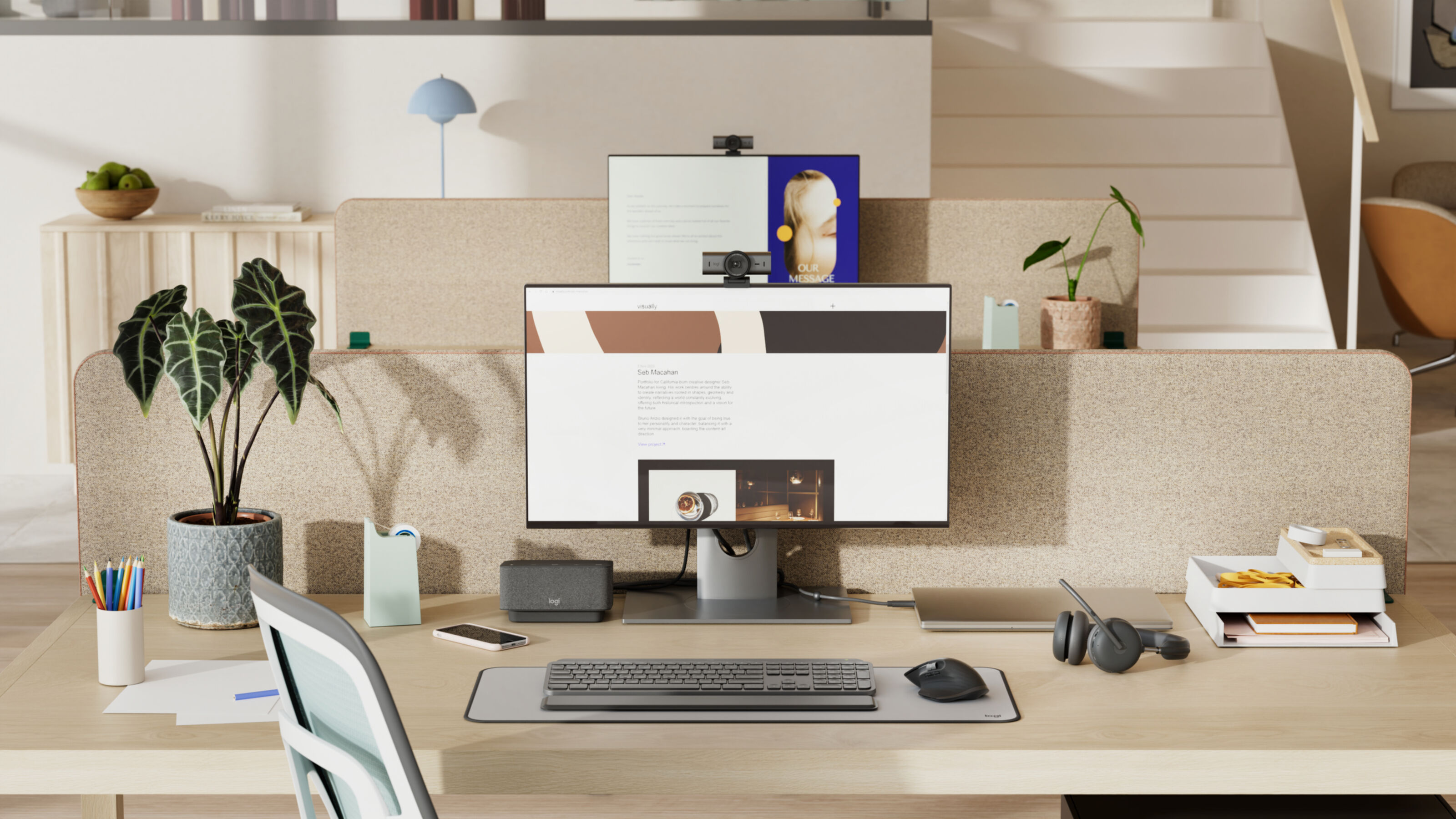 Nowoczesna przestrzeń robocza z komputerem, roślinami i artykułami biurowymi. Kamera internetowa jest na monitorze. Biurko jest drewniane.