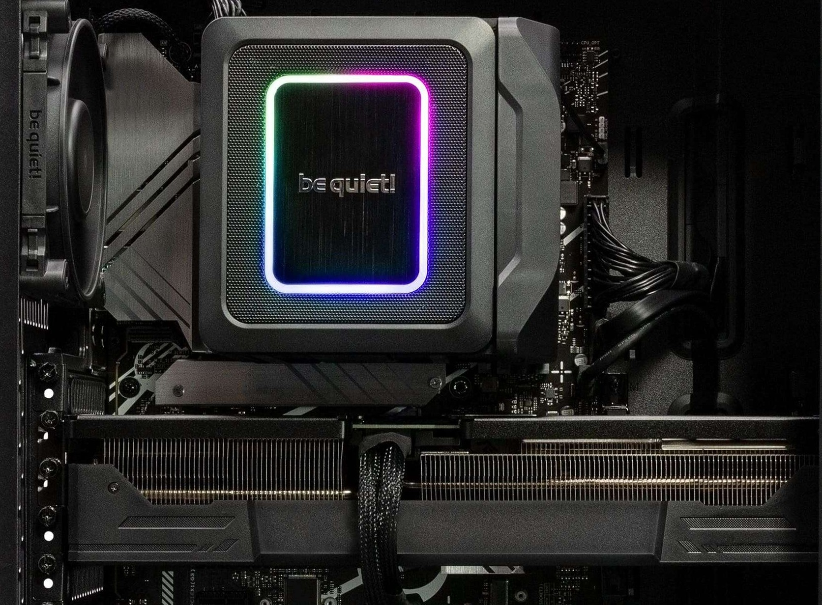 Vengono visualizzati i componenti interni di un computer, tra cui un dissipatore CPU con illuminazione RGB, una scheda grafica e vari circuiti stampati.