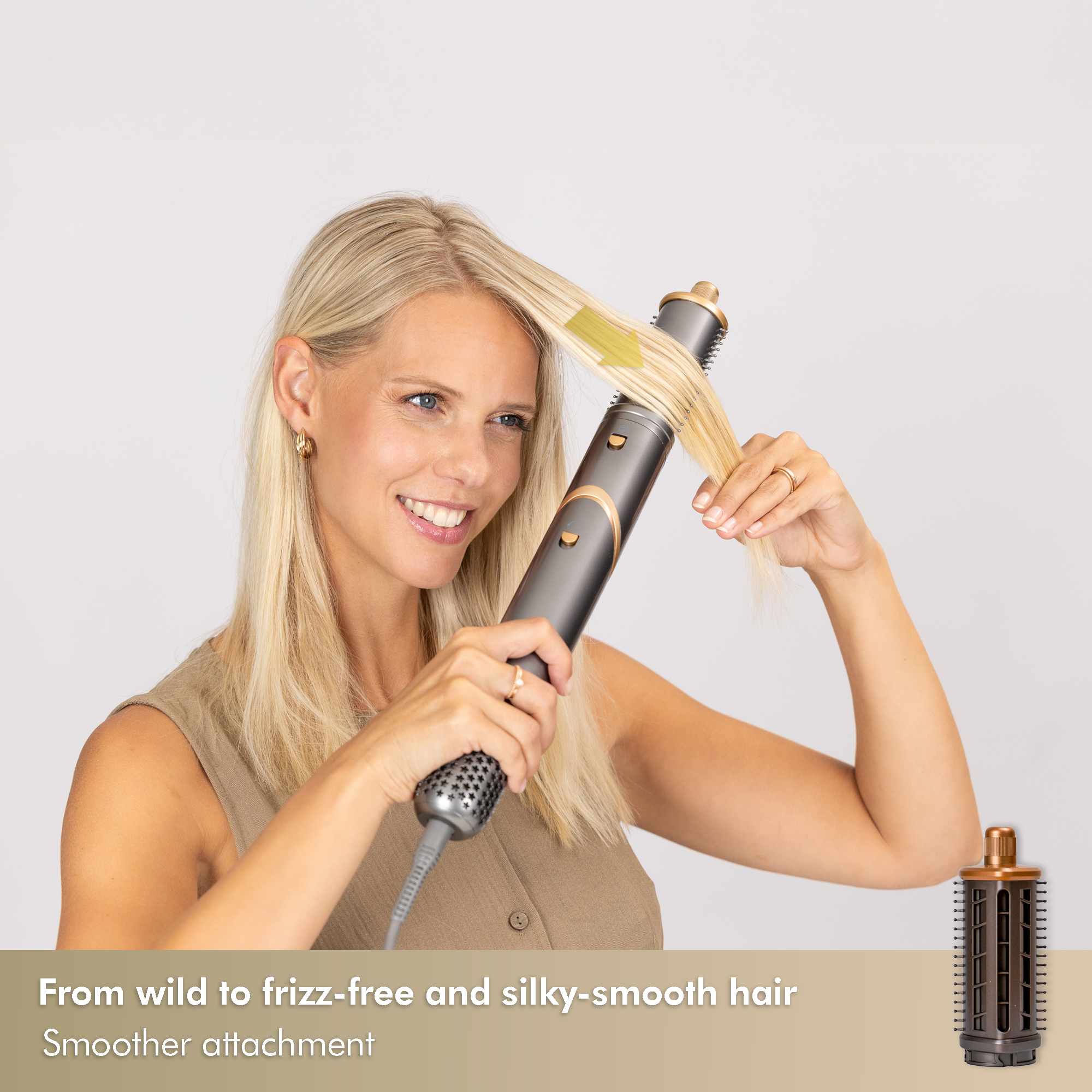 Blonde Frau, die ihr Haar mit einem grau-goldenen Haarstyling-Werkzeug stylt. Sie lächelt und hält das Werkzeug in der Nähe ihrer Haare.