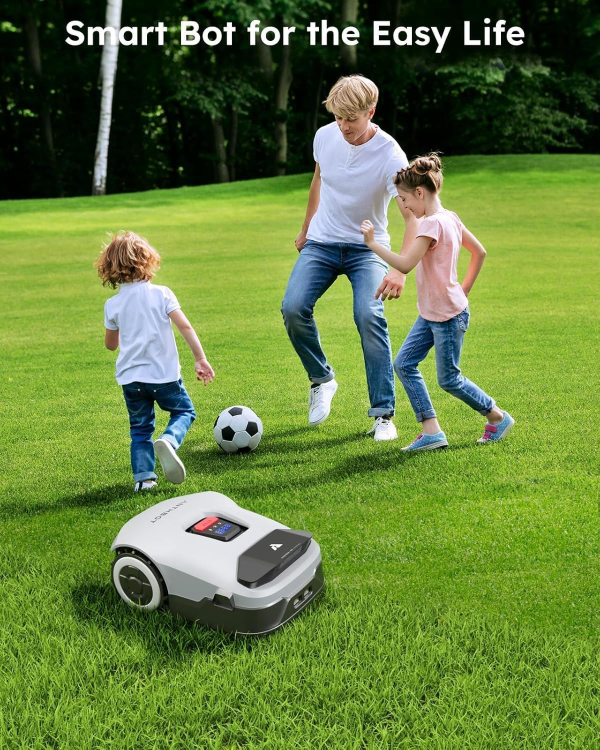 A family plays soccer on a green lawn with a robot lawnmower. The sky is blue, and trees are in the background.