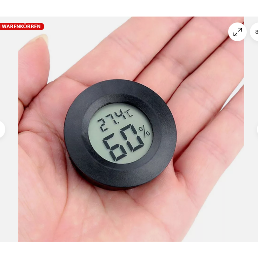 Ein kleines, schwarzes digitales Thermometer mit 27,4 °C und 60 % Luftfeuchtigkeit, gehalten in einer Handfläche vor hellem Hintergrund.