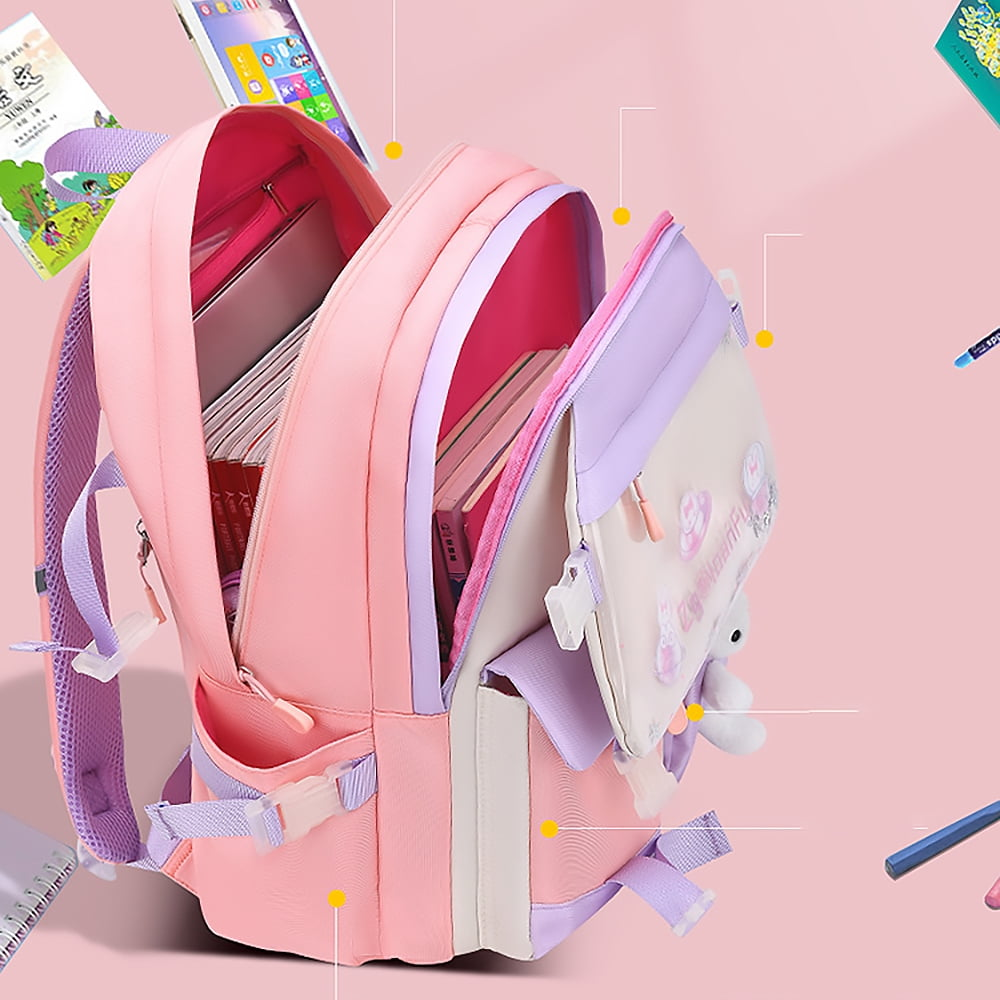Rosa-lila Rucksack mit offenen Fächern, gefüllt mit Büchern und Schreibwaren. Enthält ein kleines Spielzeugkaninchen, auf rosa Hintergrund.