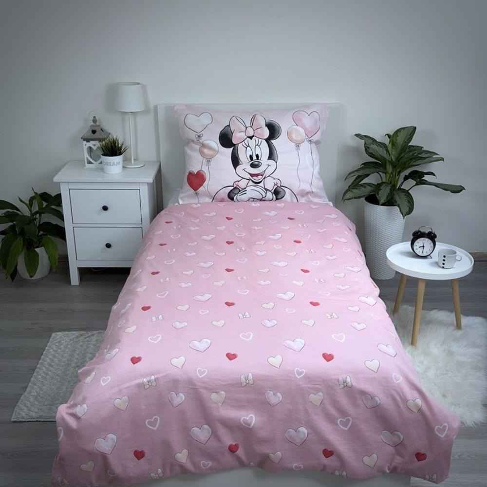 Rosa Bett mit Minnie Maus. Herzen auf der Bettdecke. Pflanzen an der Seite. Wecker und kleiner Tisch. Weiße Wände im Hintergrund.