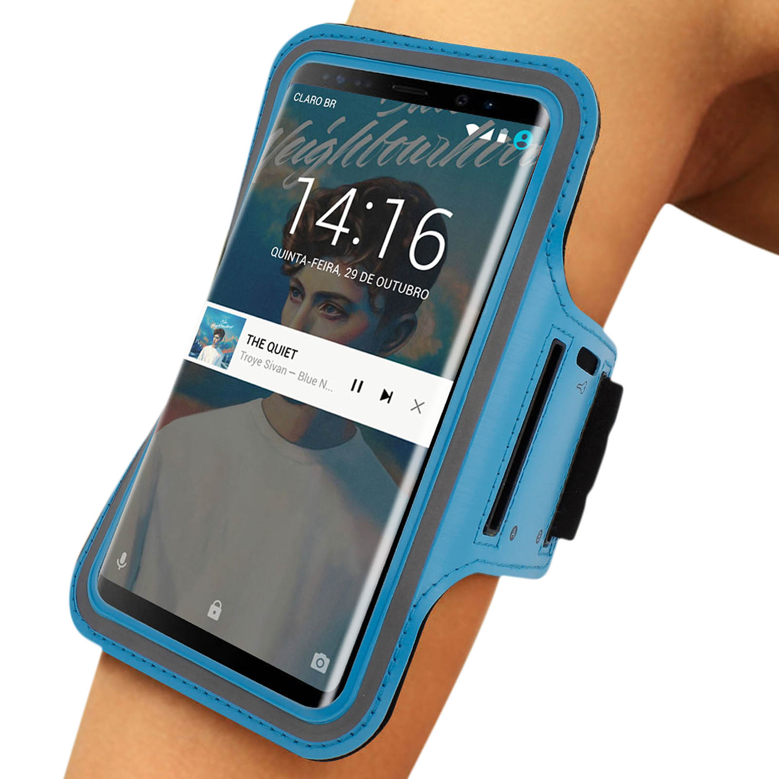 Un smartphone dans un brassard bleu affiche un lecteur de musique. L'écran affiche l'heure et les détails de la chanson. Le brassard est sur un bras.