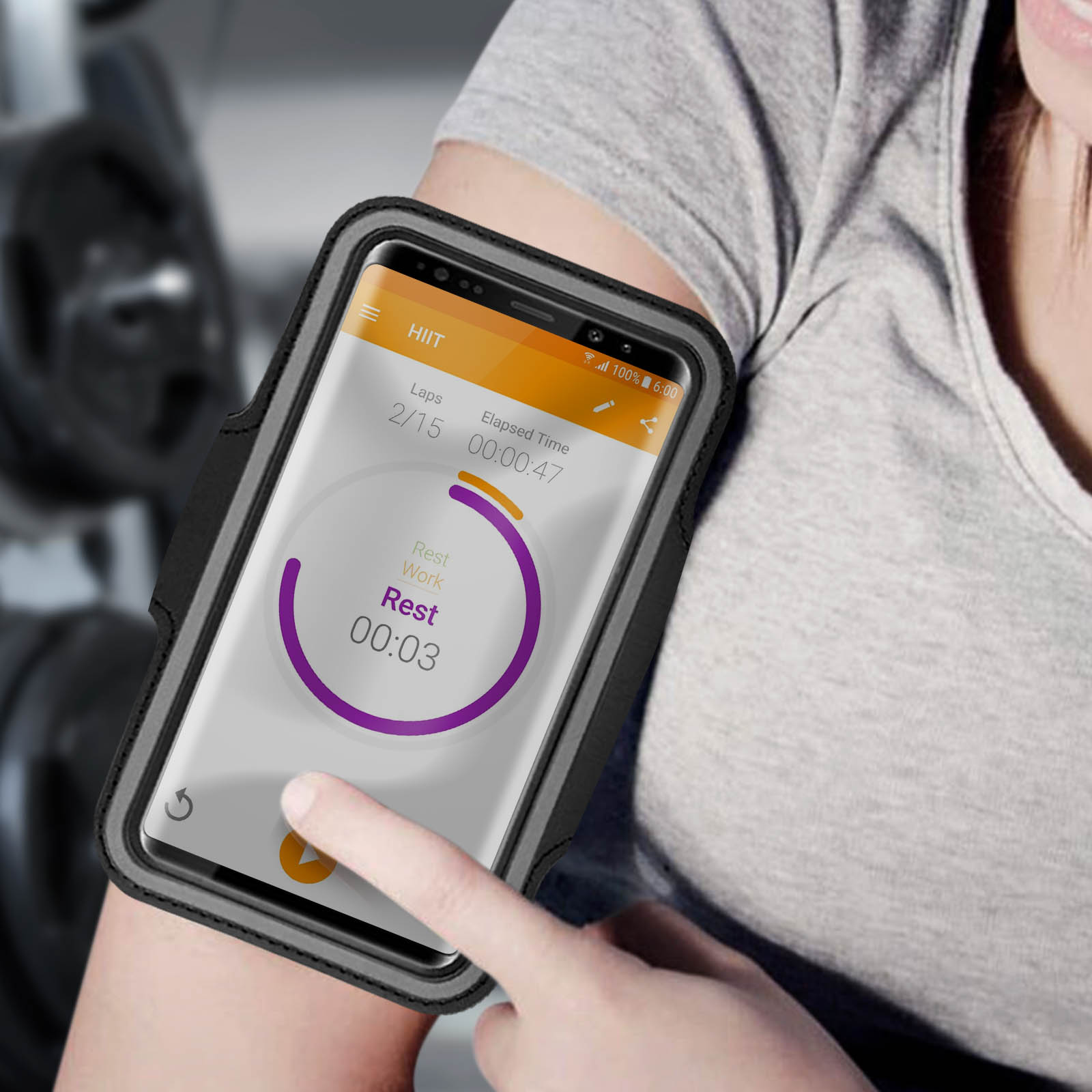 Une personne portant un brassard avec un téléphone, affichant une application d'entraînement. L'écran affiche le temps de repos.