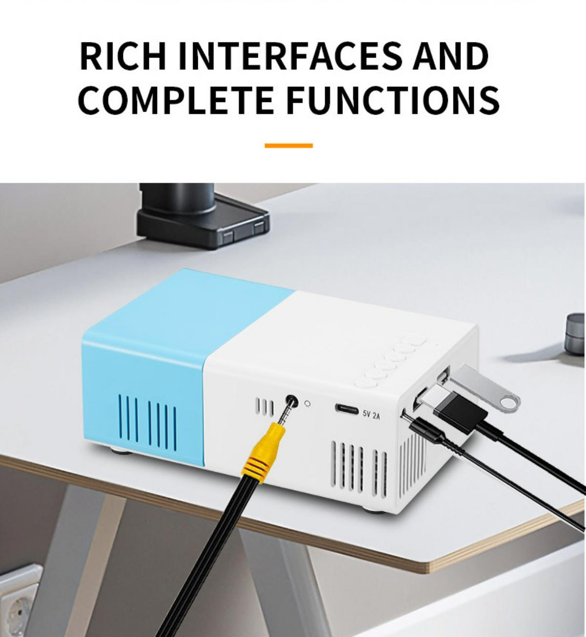 Ein weißer und blauer Projektor mit verschiedenen Anschlüssen steht auf einer weißen Oberfläche. Kabel sind eingesteckt. Oben steht: RICH INTERFACES AND COMPLETE FUNCTIONS.
