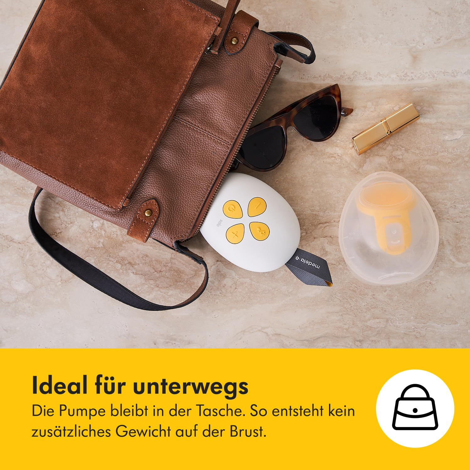 Eine braune Handtasche ist geöffnet, mit Sonnenbrille, Lippenstift und einer Brustpumpe. Ein gelbes Brustpumpenteil liegt daneben.