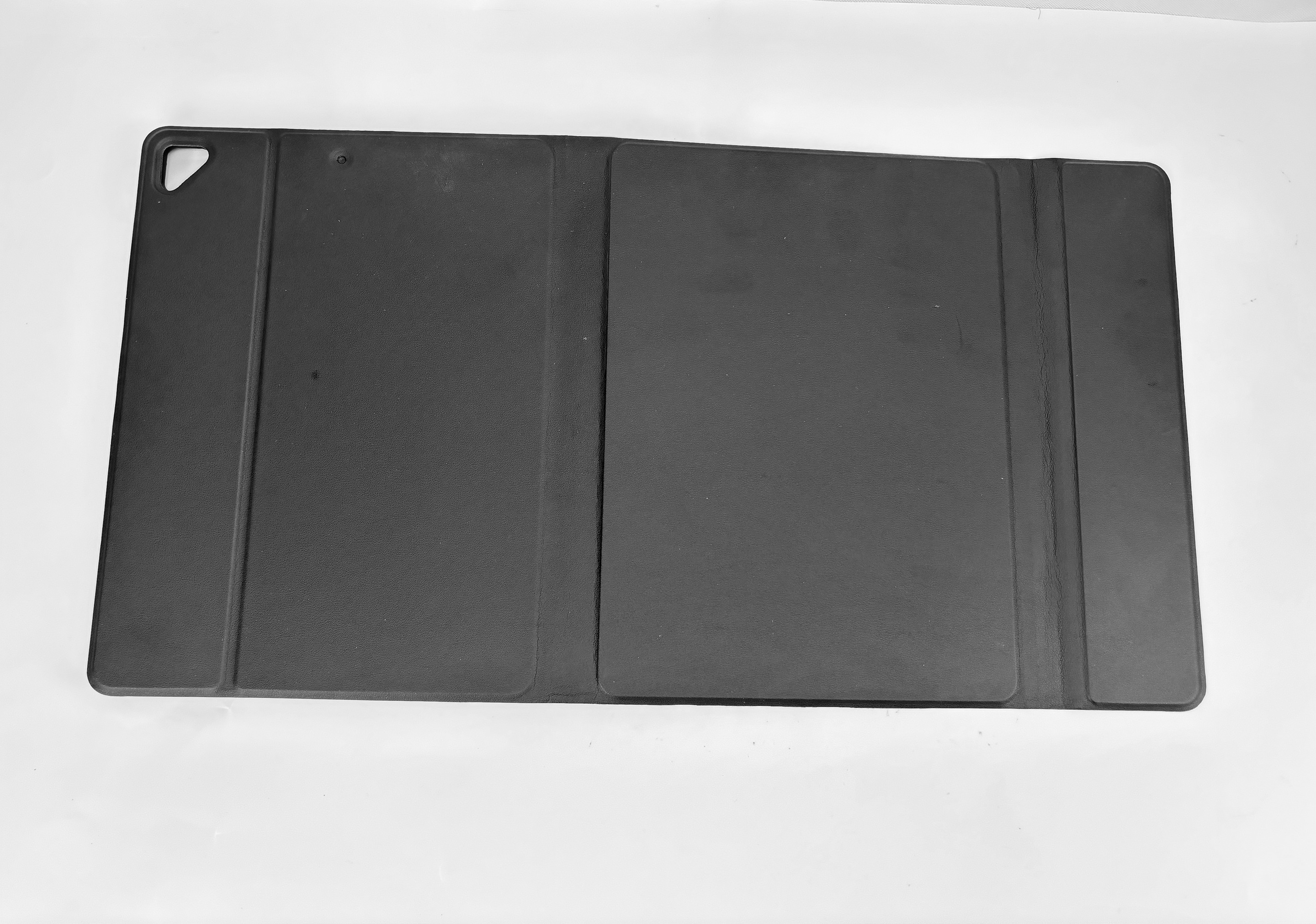 Una custodia nera per tablet è aperta su sfondo bianco. La custodia è rettangolare con tre sezioni e un'asola angolare.