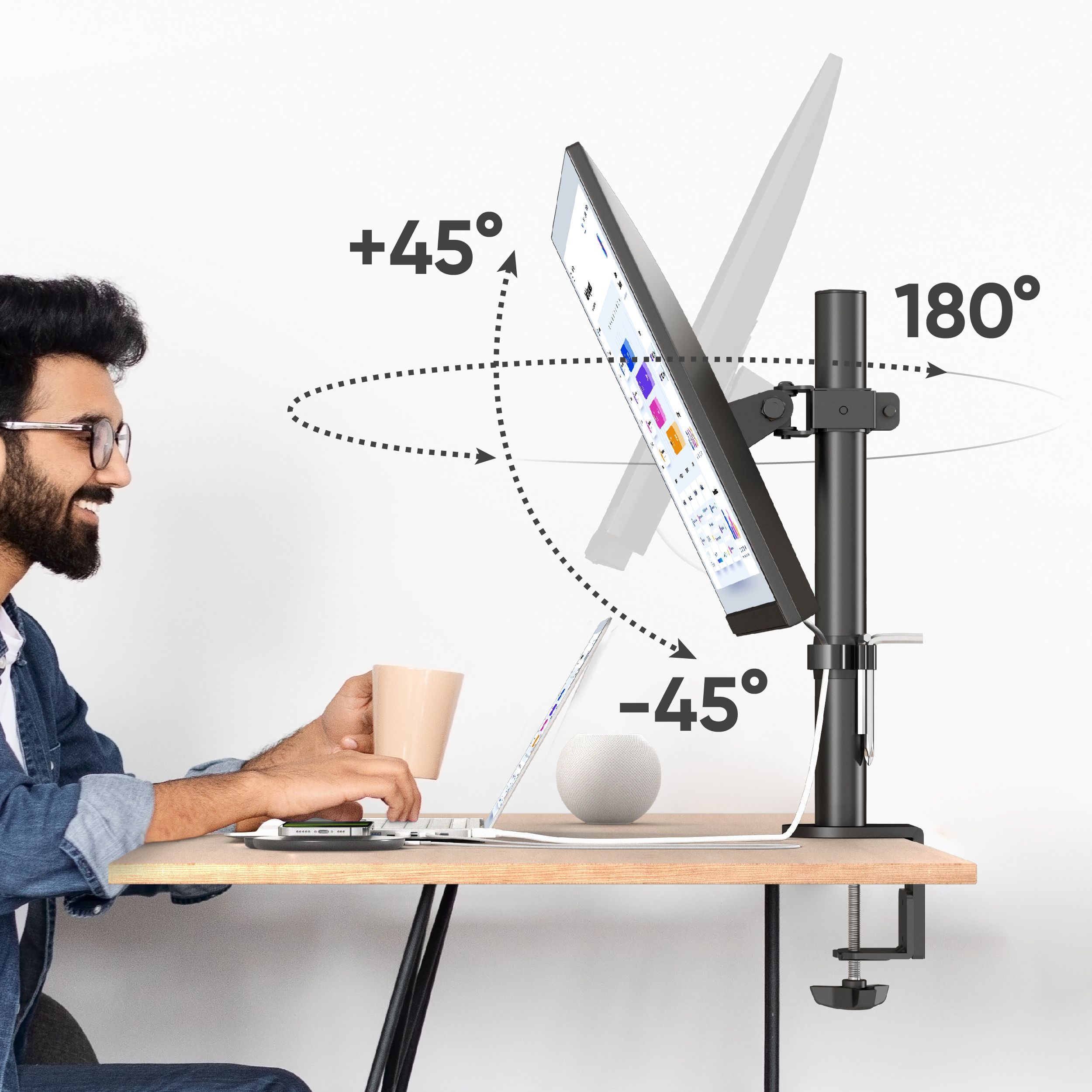 Hombre usando laptop con soporte de monitor, sosteniendo una taza. El monitor puede girar. Fondo blanco.
