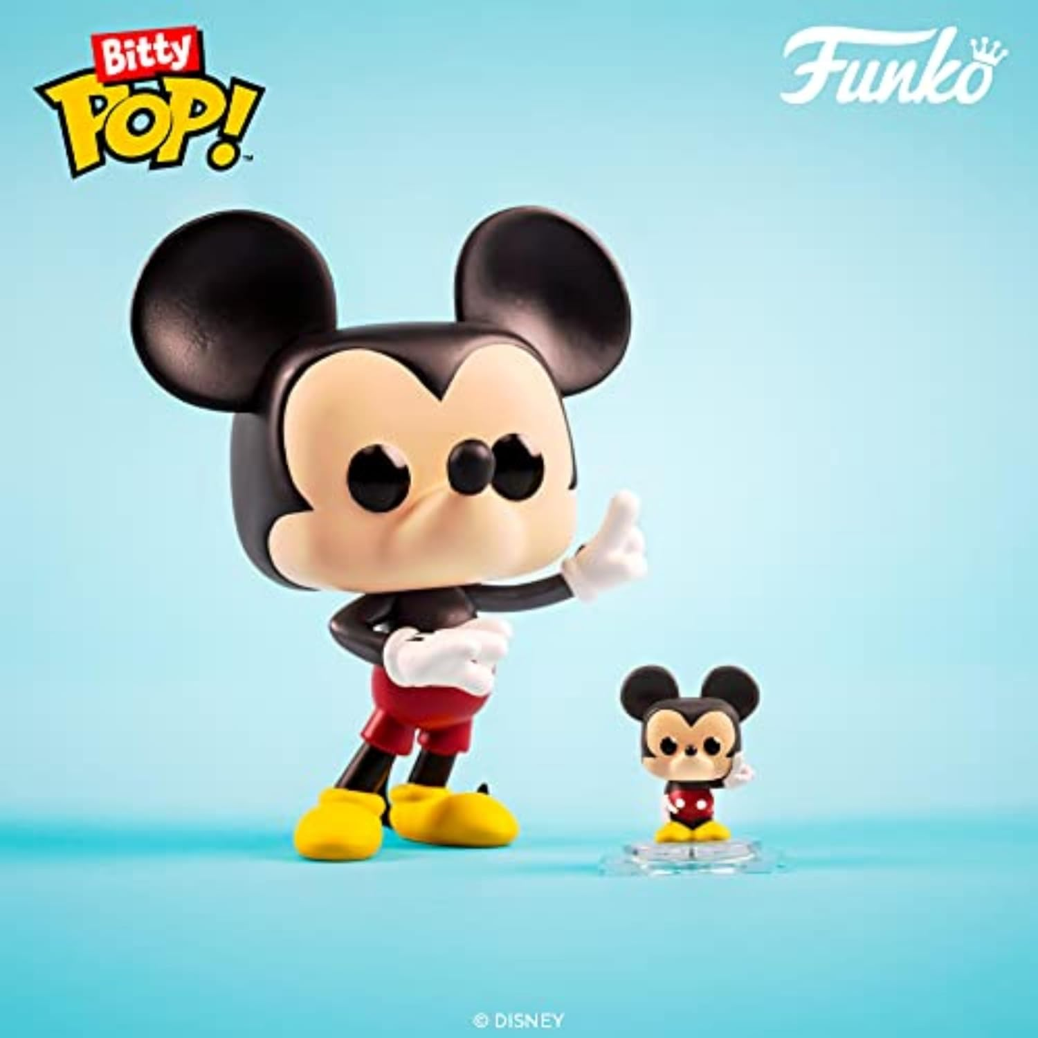 Dwie figurki Mickey Mouse Funko Pop. Duża z żółtymi butami i czerwonymi szortami oraz mniejsza na podstawce. Niebieskie tło.