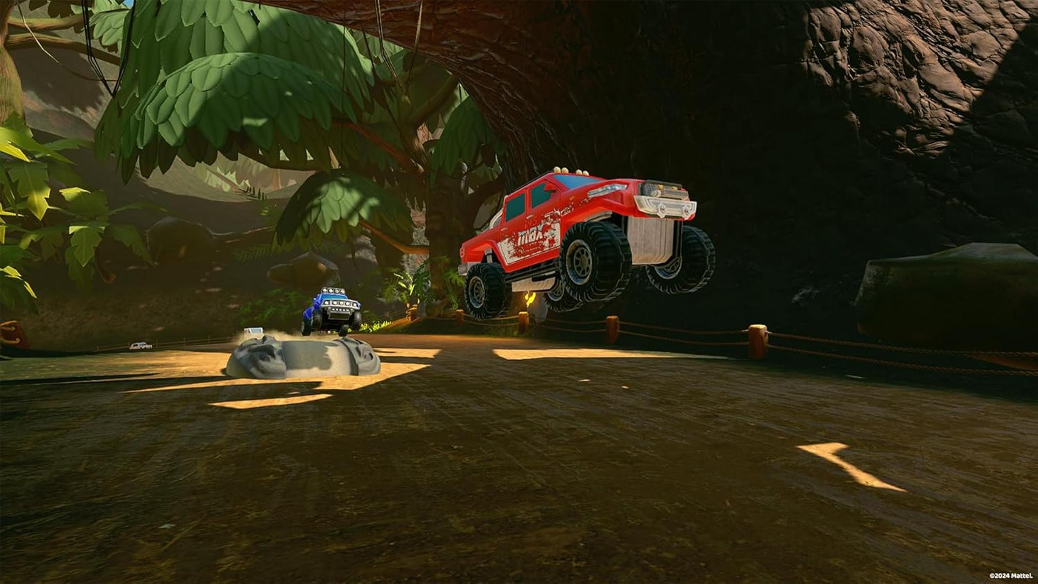 Ein roter Monstertruck springt über eine Dirt-Strecke. Im Hintergrund ist ein blauer Truck zu sehen. Die Szene spielt in einer Dschungelumgebung.