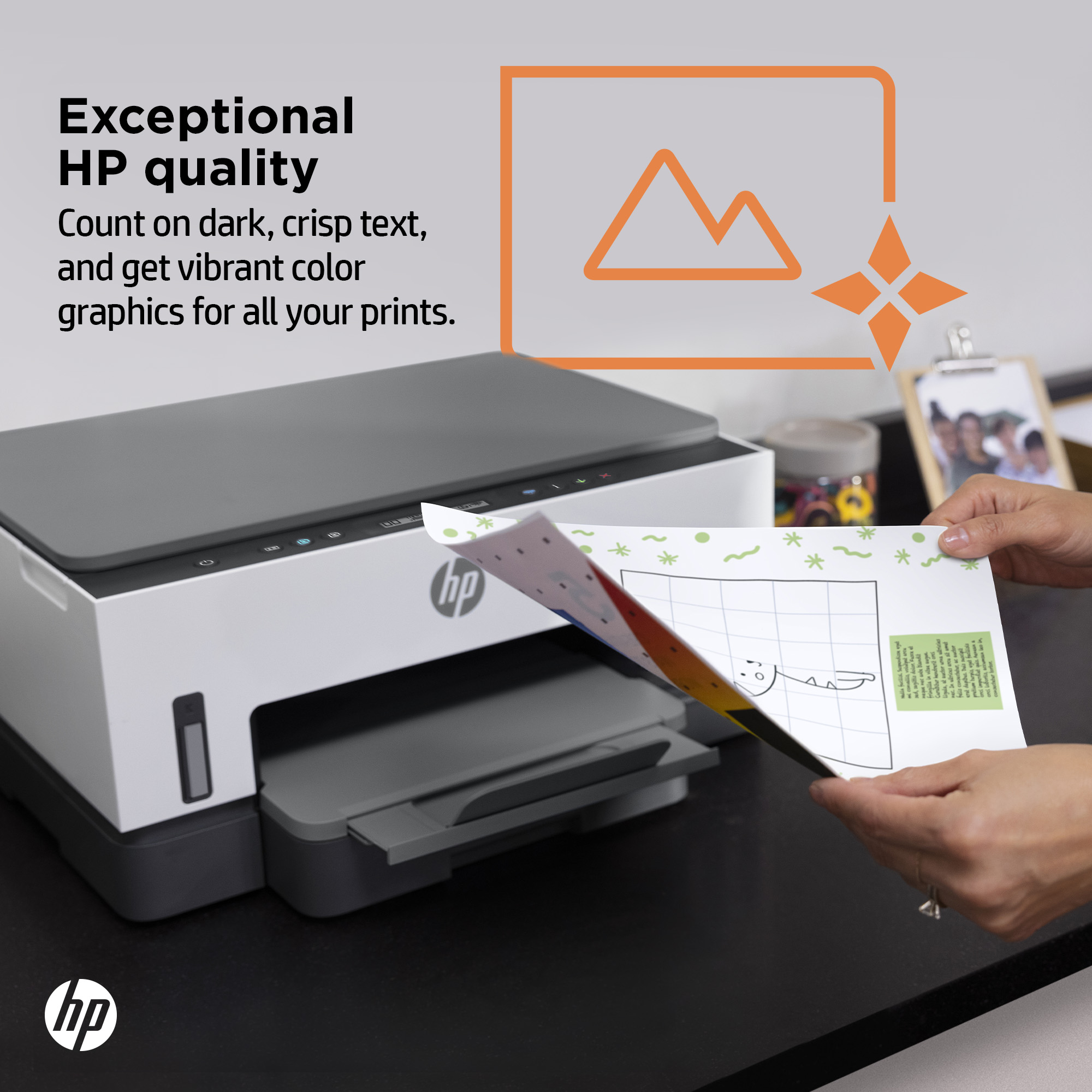 Una stampante HP è mostrata con una pagina stampata. Una persona tiene in mano la carta, la stampante è bianca e grigia.