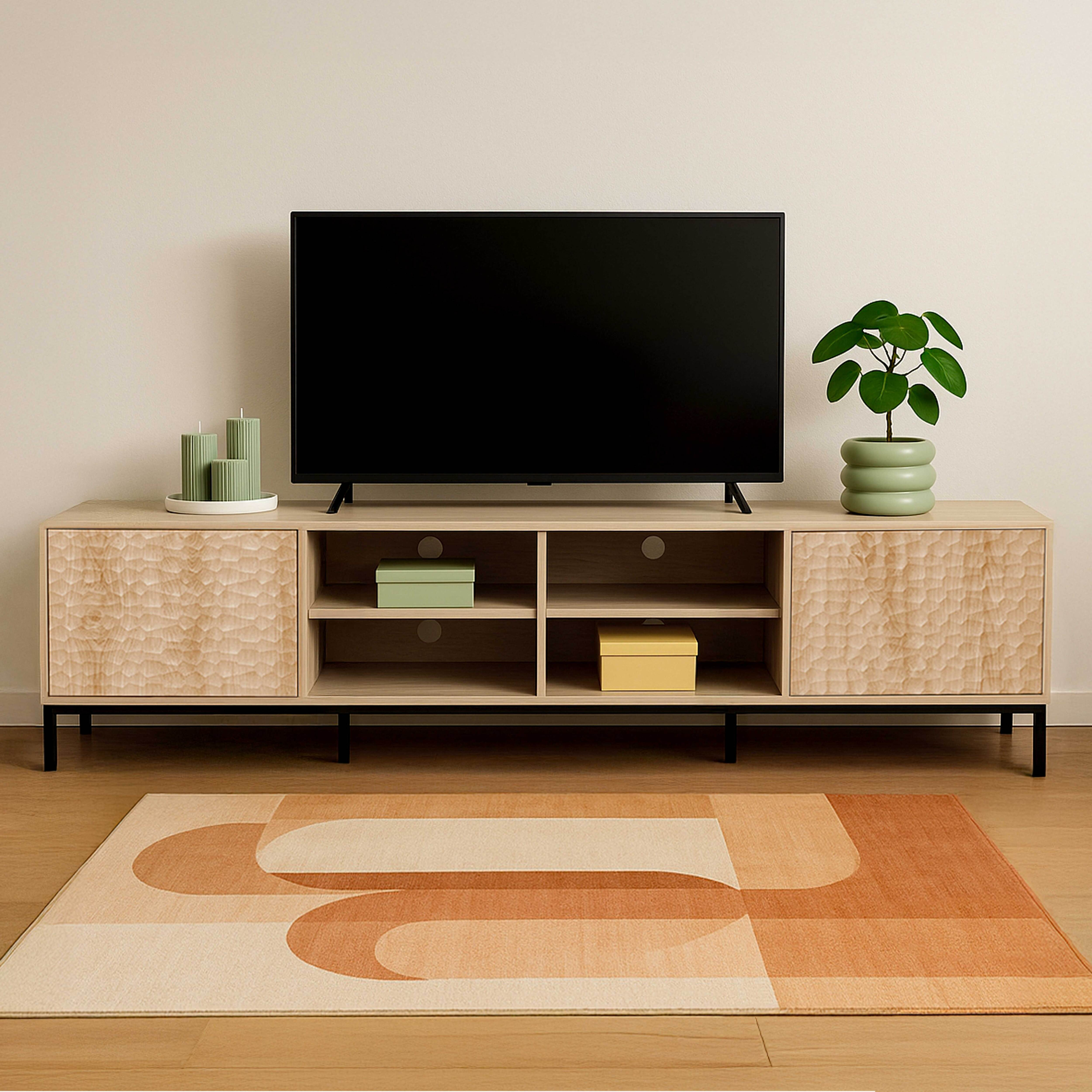 Ein modernes Wohnzimmer mit Fernseher, Holzschrank, Teppich und Pflanze. Der Raum hat eine cremefarbene Wand.
