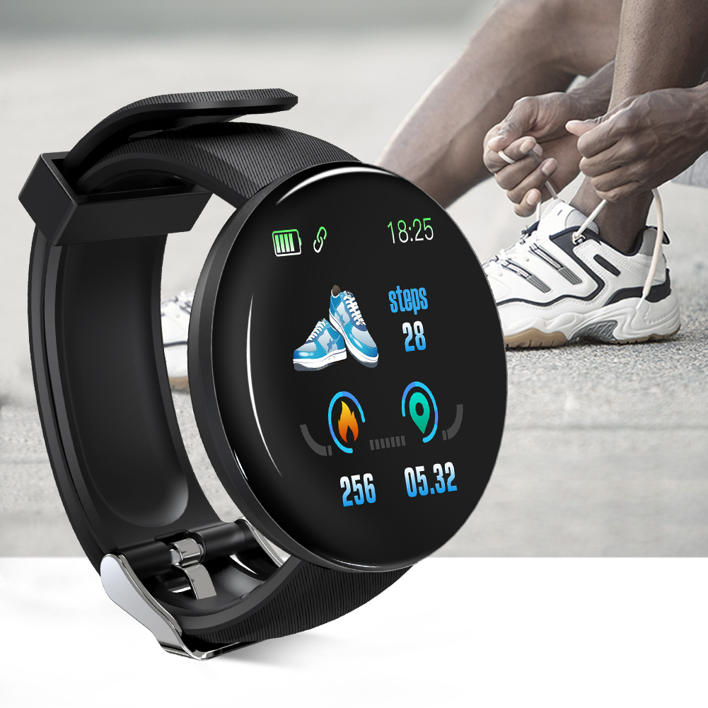 Eine schwarze Smartwatch zeigt Schritte und Zeit an. Eine Person im Hintergrund bindet sich die Schuhe.