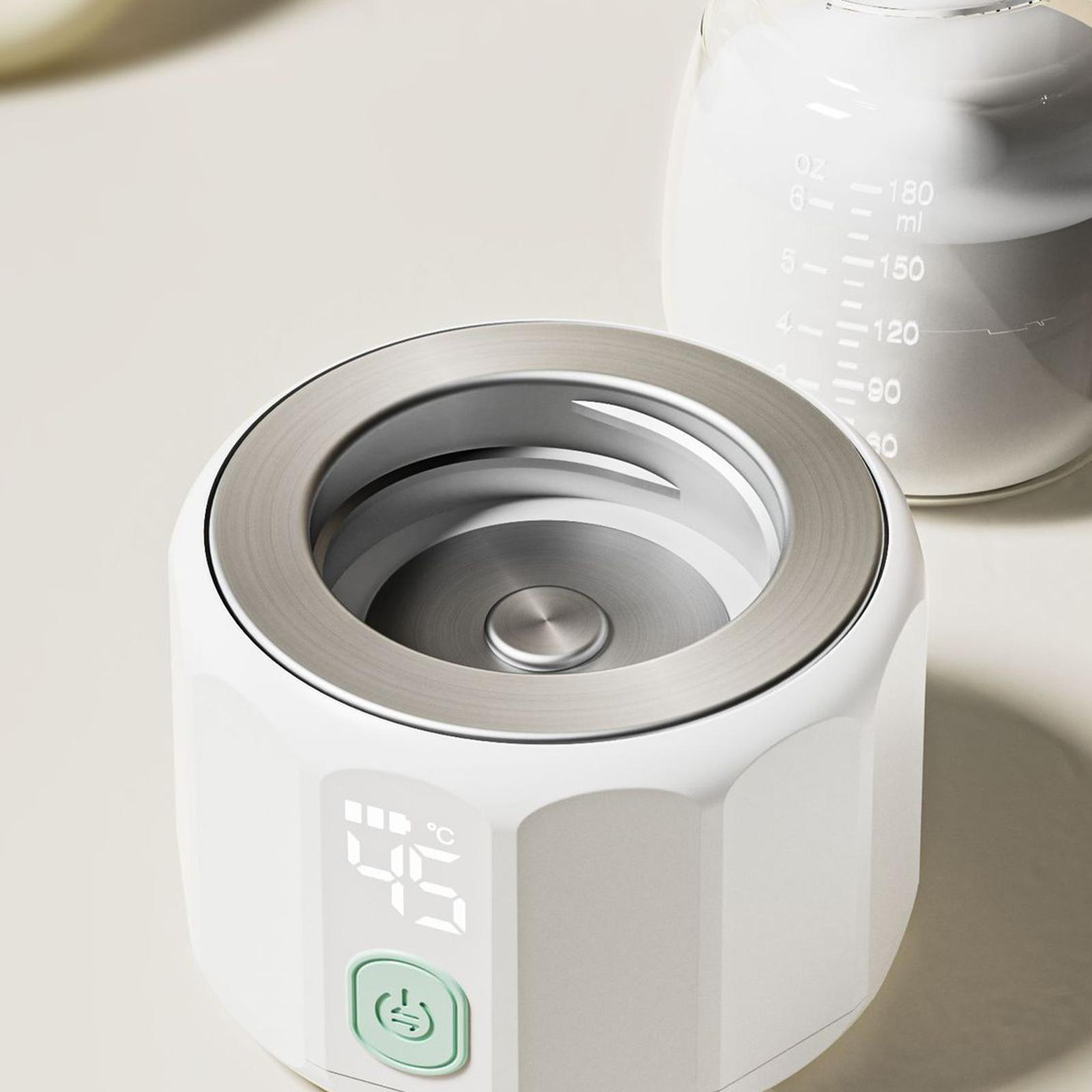 Ein weißer Babyflaschenwärmer mit Digitalanzeige, die 45 Grad Celsius anzeigt, und eine Glasflasche im Hintergrund.