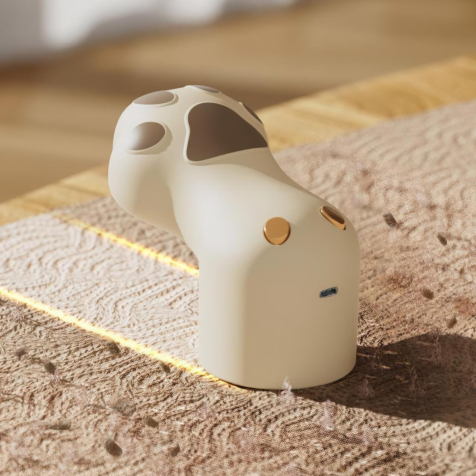 Beige Gerät mit braunen Akzenten auf einem gemusterten Teppich. Das Gerät hat eine einzigartige Form mit Löchern und Knöpfen.