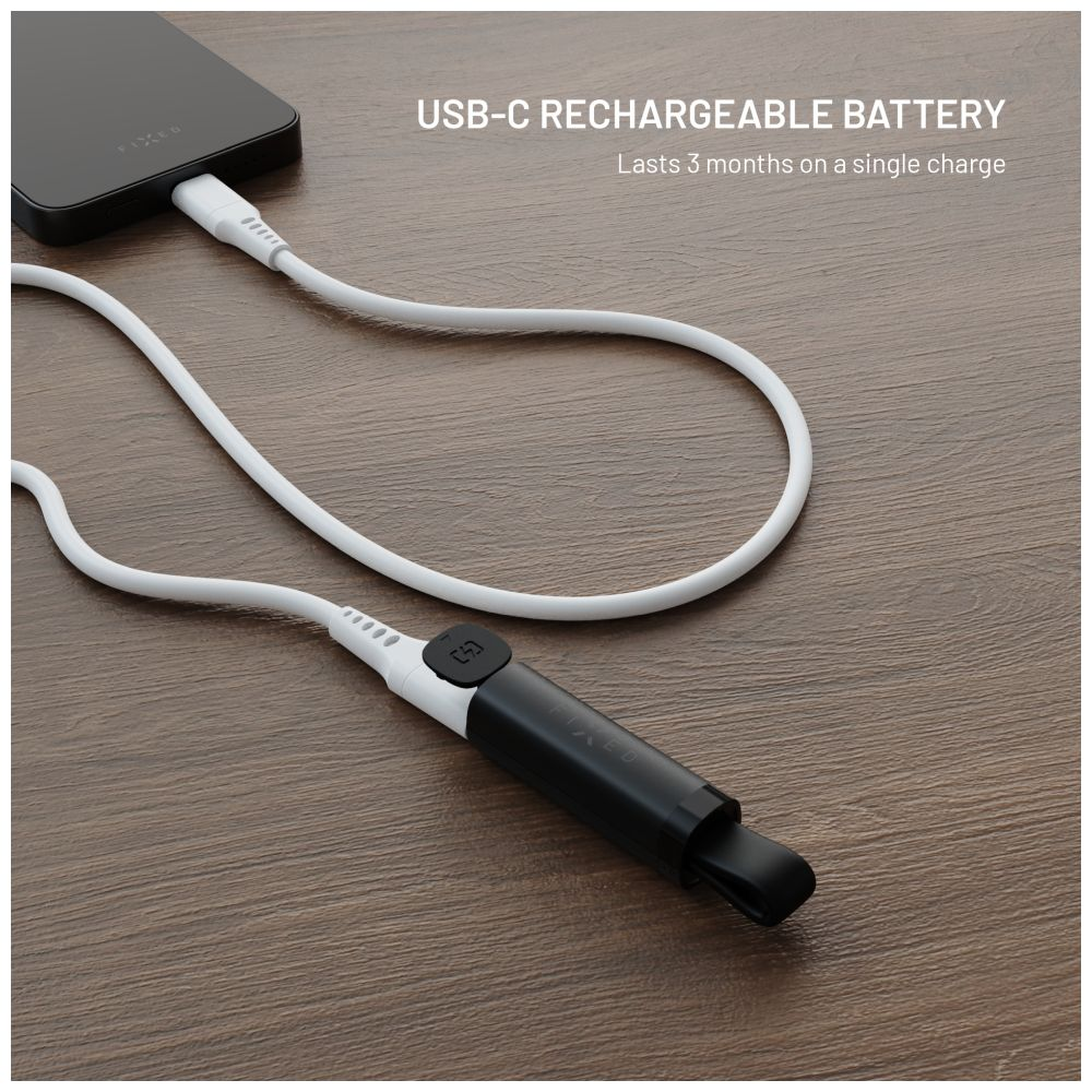 Ein schwarzes Telefon wird mit einem weißen Kabel von einem schwarz-weißen USB-C-Akku auf einer braunen Holzoberfläche aufgeladen.