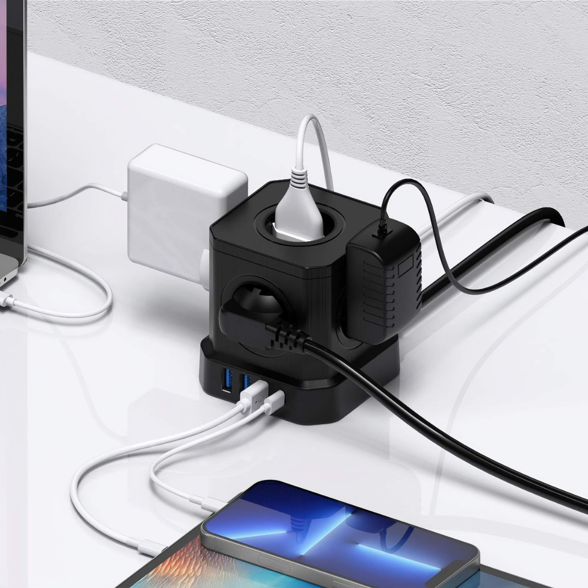 Schwarze Steckdosenleiste mit mehreren Steckern und USB-Anschlüssen. Verbunden mit Telefon, Tablet und Laptop. Weiße Ladegeräte sind ebenfalls vorhanden.