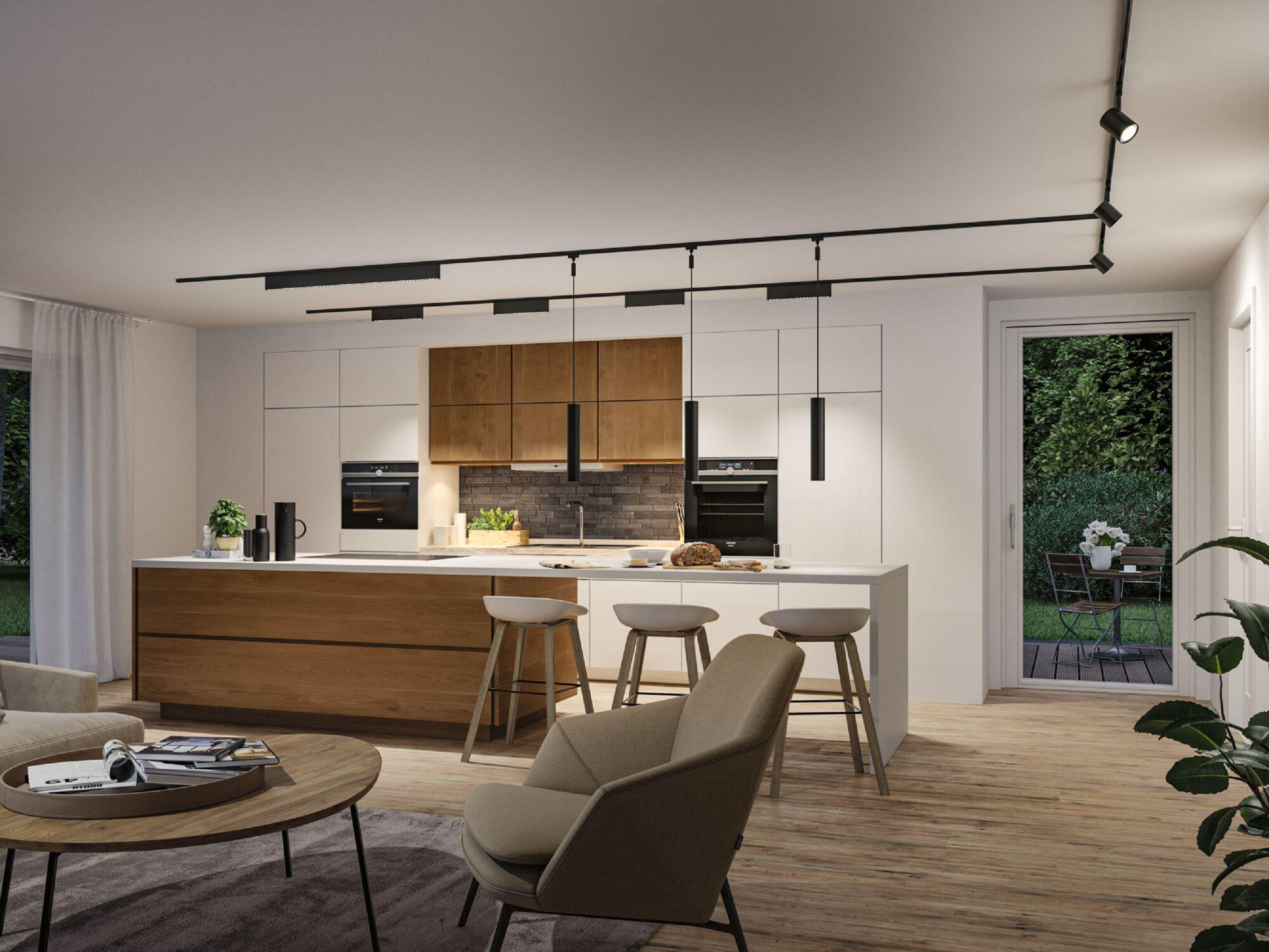 Nowoczesna kuchnia z wyspą, stołkami i urządzeniami. Salon z krzesłami, stolikiem kawowym i widokiem na zewnątrz.