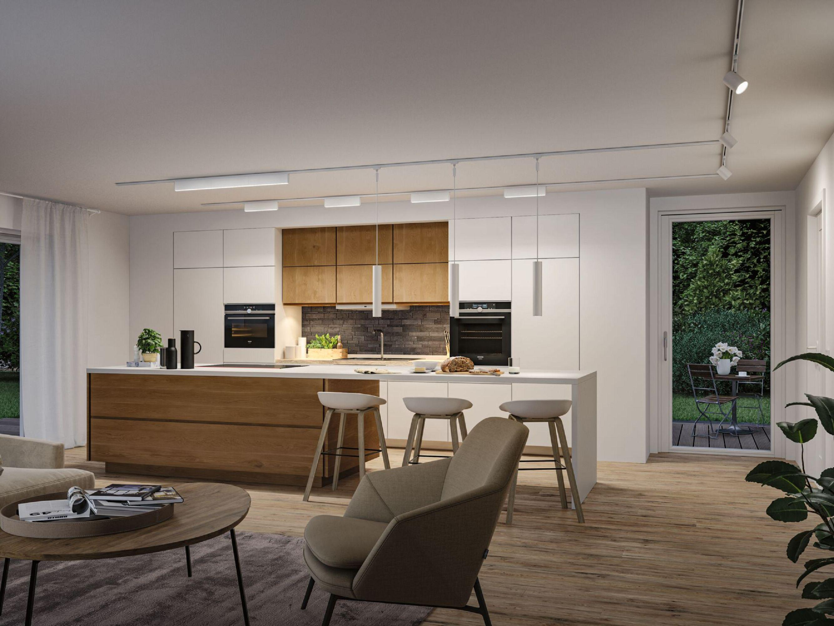 Nowoczesna kuchnia z wyspą, stołkami i urządzeniami. Stół jadalny na zewnątrz. Część dzienna z sofą i stolikiem kawowym.