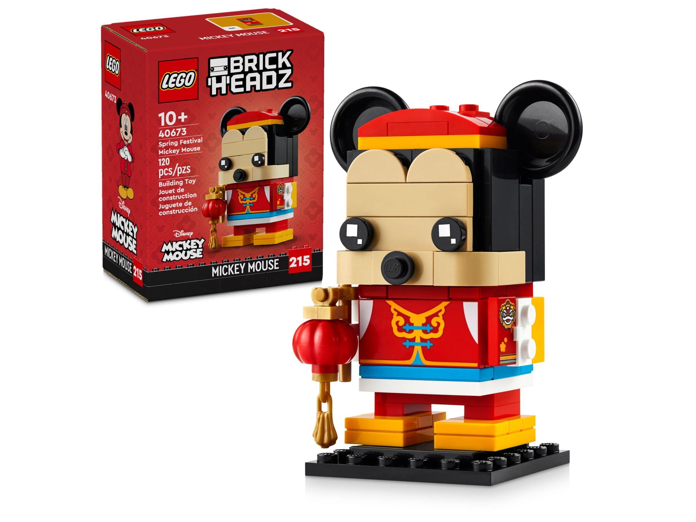 Eine Lego-Mickey-Mouse-Figur in roter Kleidung, die eine Laterne hält. Im Hintergrund ist eine Lego-Box zu sehen.