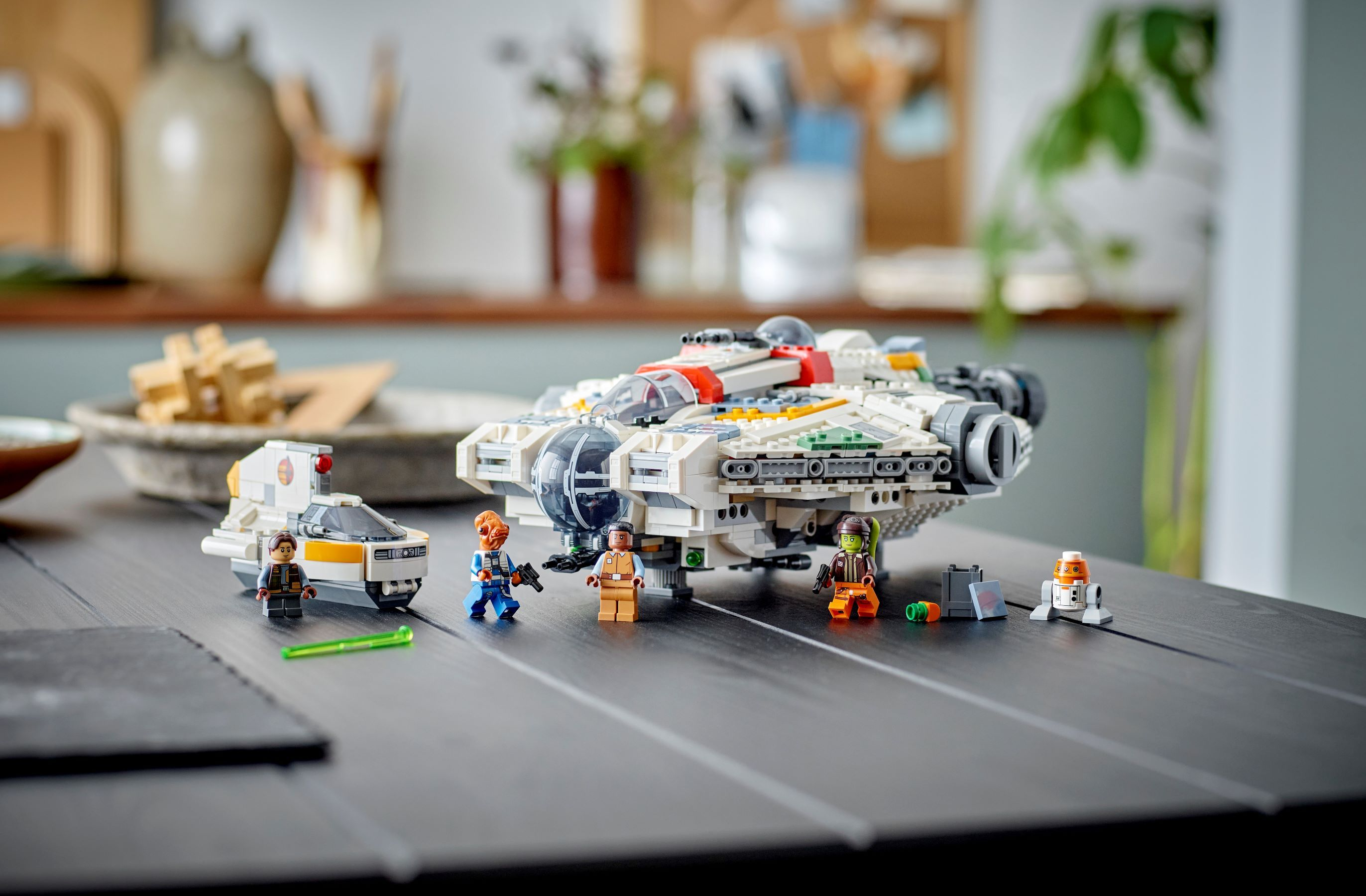 Zestaw Lego Star Wars z Sokółem Millennium, Y-wingiem i minifigurkami na czarnym stole.