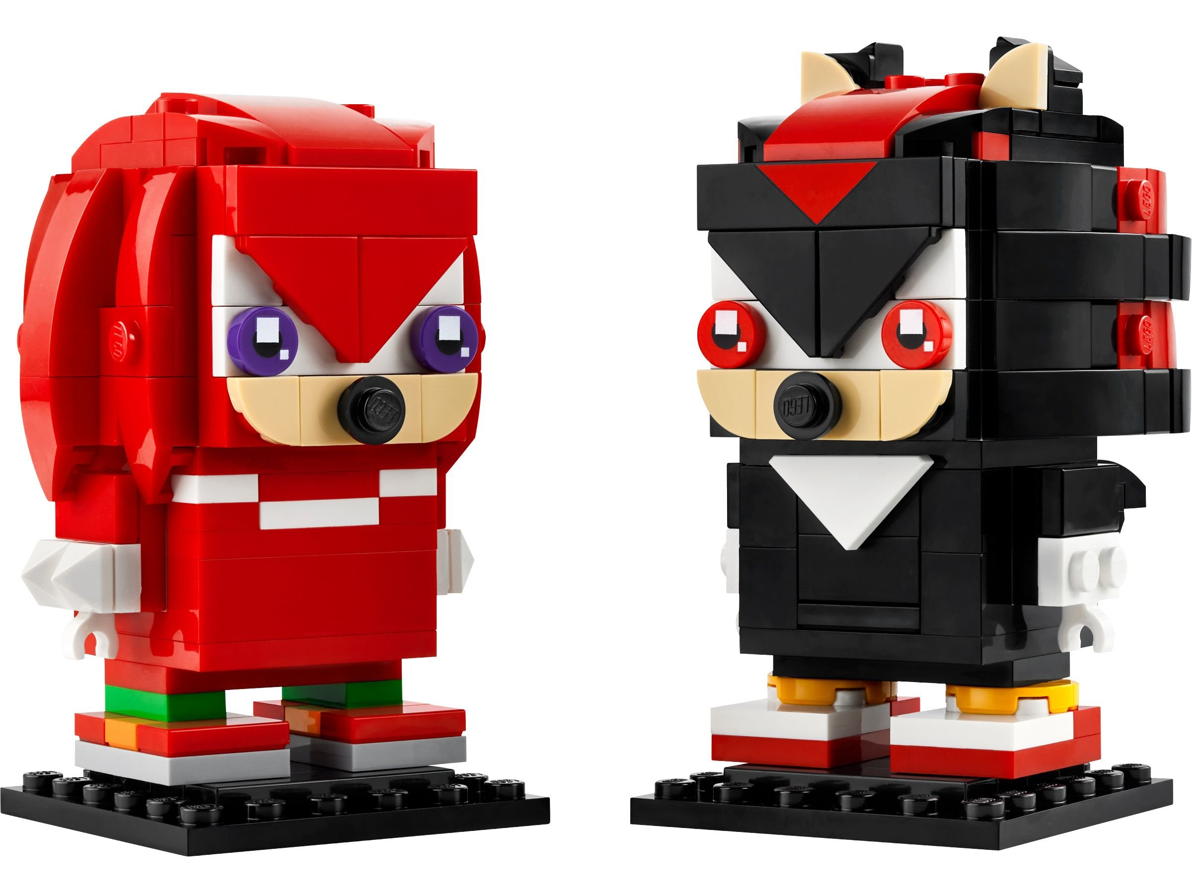 Zwei Lego-Figuren, Knuckles und Shadow, stehen nebeneinander. Knuckles ist rot, Shadow ist schwarz. Beide stehen auf schwarzen Sockeln.