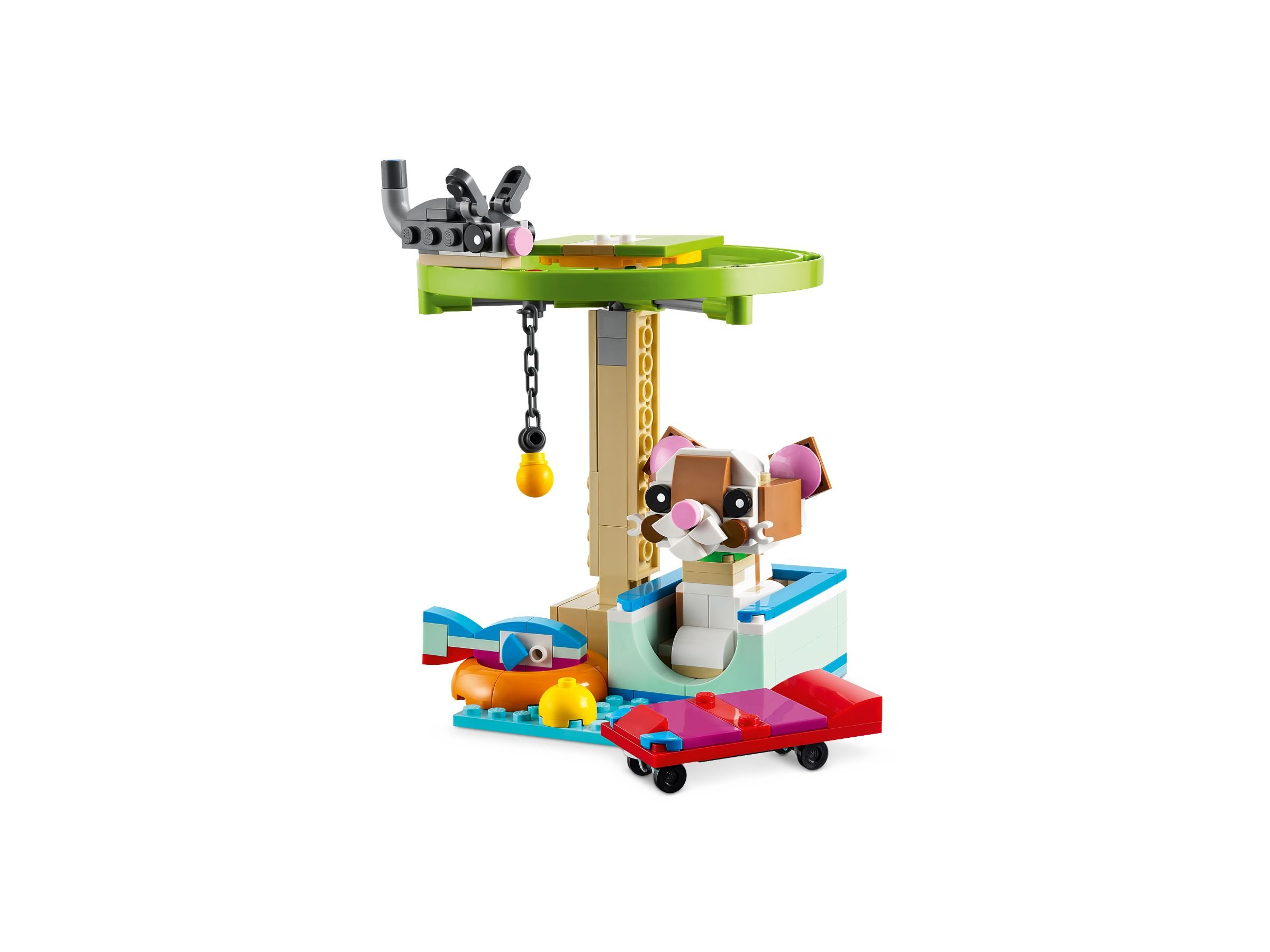 Set Lego. Un gatto seduto in una scatola blu. Include uno skateboard, un pesce, una palla e una piattaforma verde.