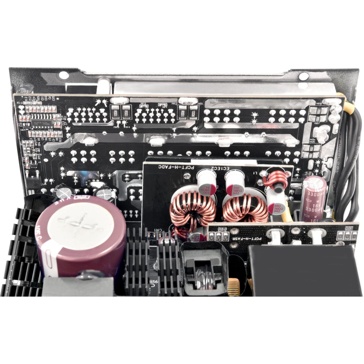Eine schwarze Leiterplatte mit verschiedenen elektronischen Bauteilen, darunter Kondensatoren, Induktivitäten und Verkabelung. Der Hintergrund ist weiß.