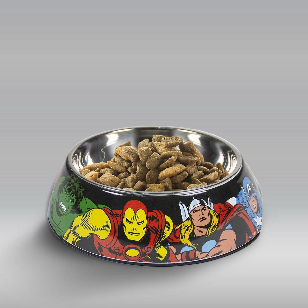 Una ciotola per animali a tema Marvel piena di crocchette. La ciotola presenta Iron Man, Thor, Hulk e Capitan America. Base nera con interno argentato.