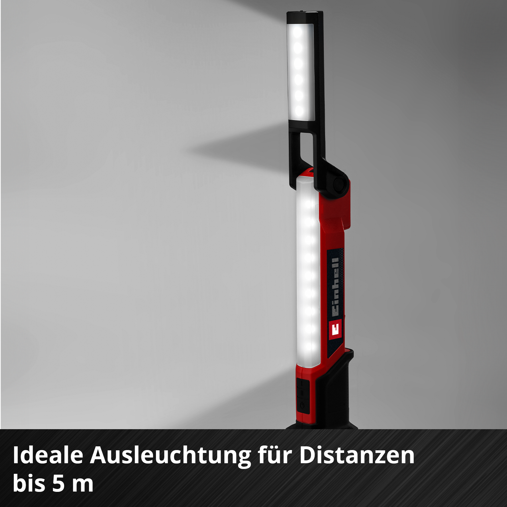 Eine rot-schwarze LED-Arbeitsleuchte wird vor grauem Hintergrund gezeigt. Die Leuchte ist mit 'Einhell' beschriftet.