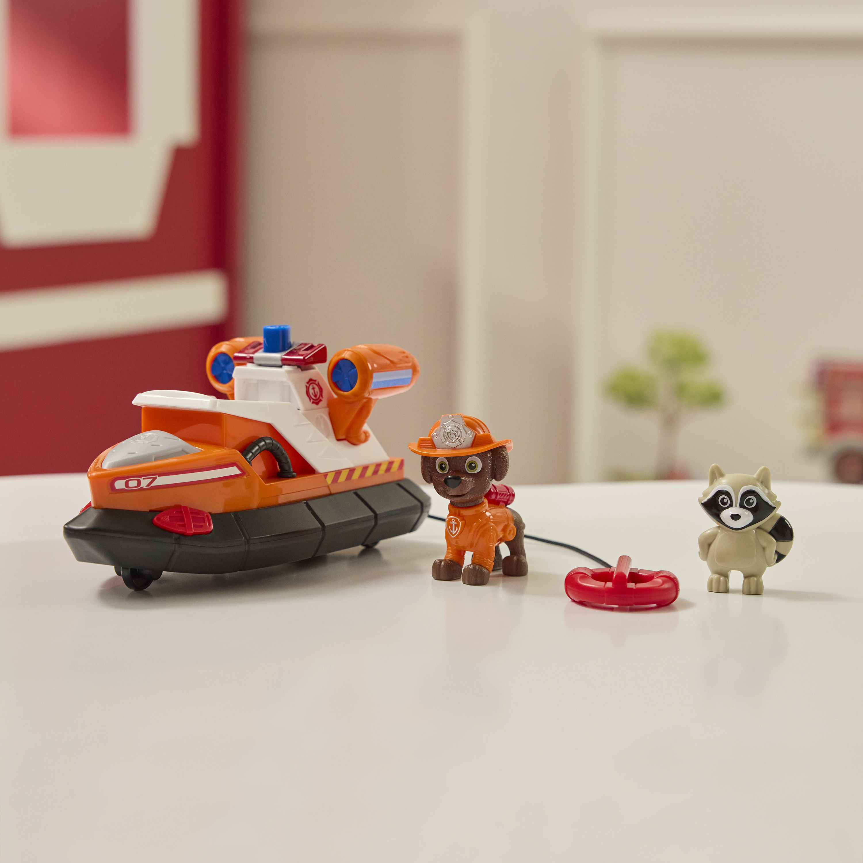 Zestaw zabawek Paw Patrol z poduszkowcem, Marshallem i szopem na białej powierzchni.