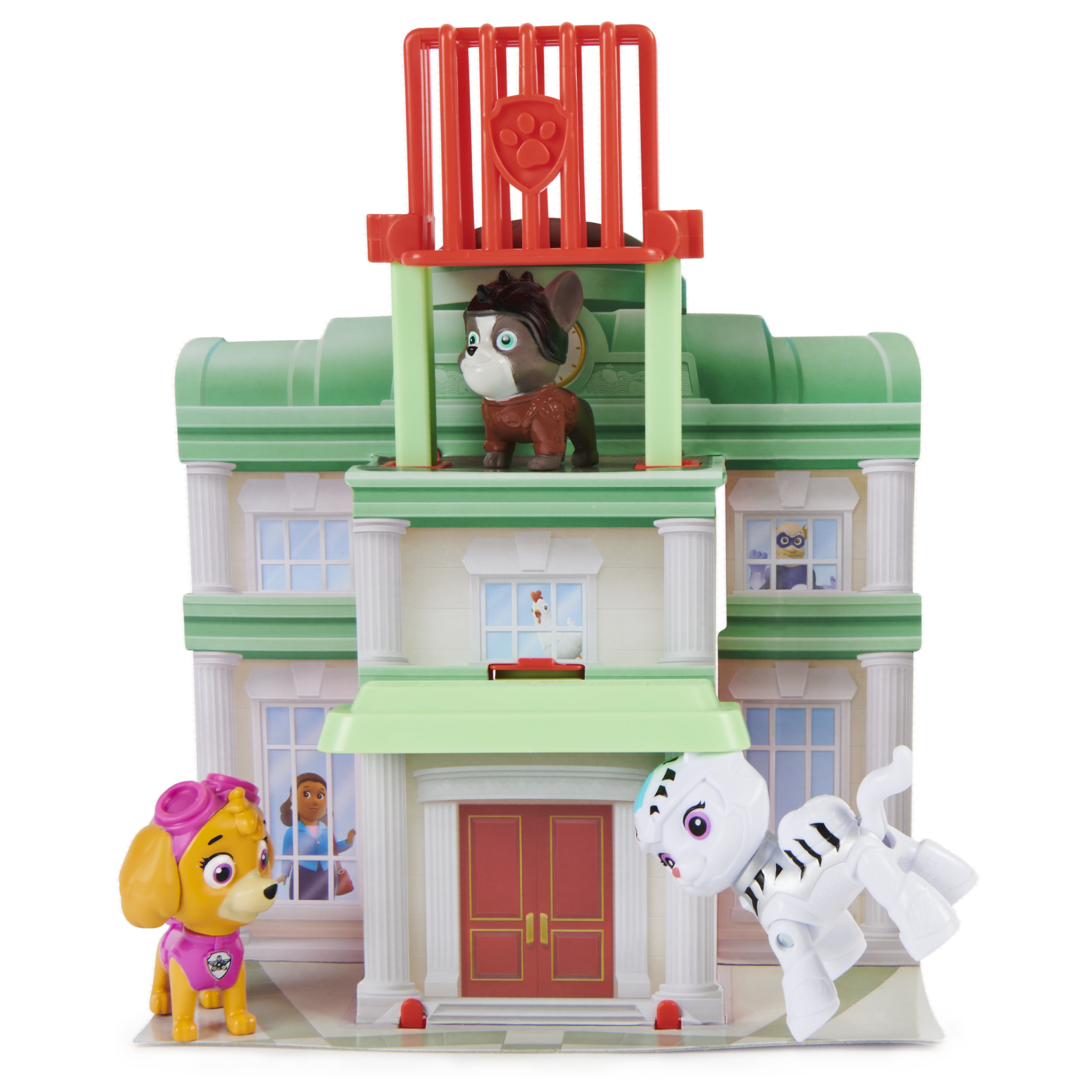 Ein Spielzeuggebäude mit Paw Patrol-Figuren. Ein brauner Hund, ein weißer Hund und ein gelber Hund. Ein Huhn ist in einem Fenster.