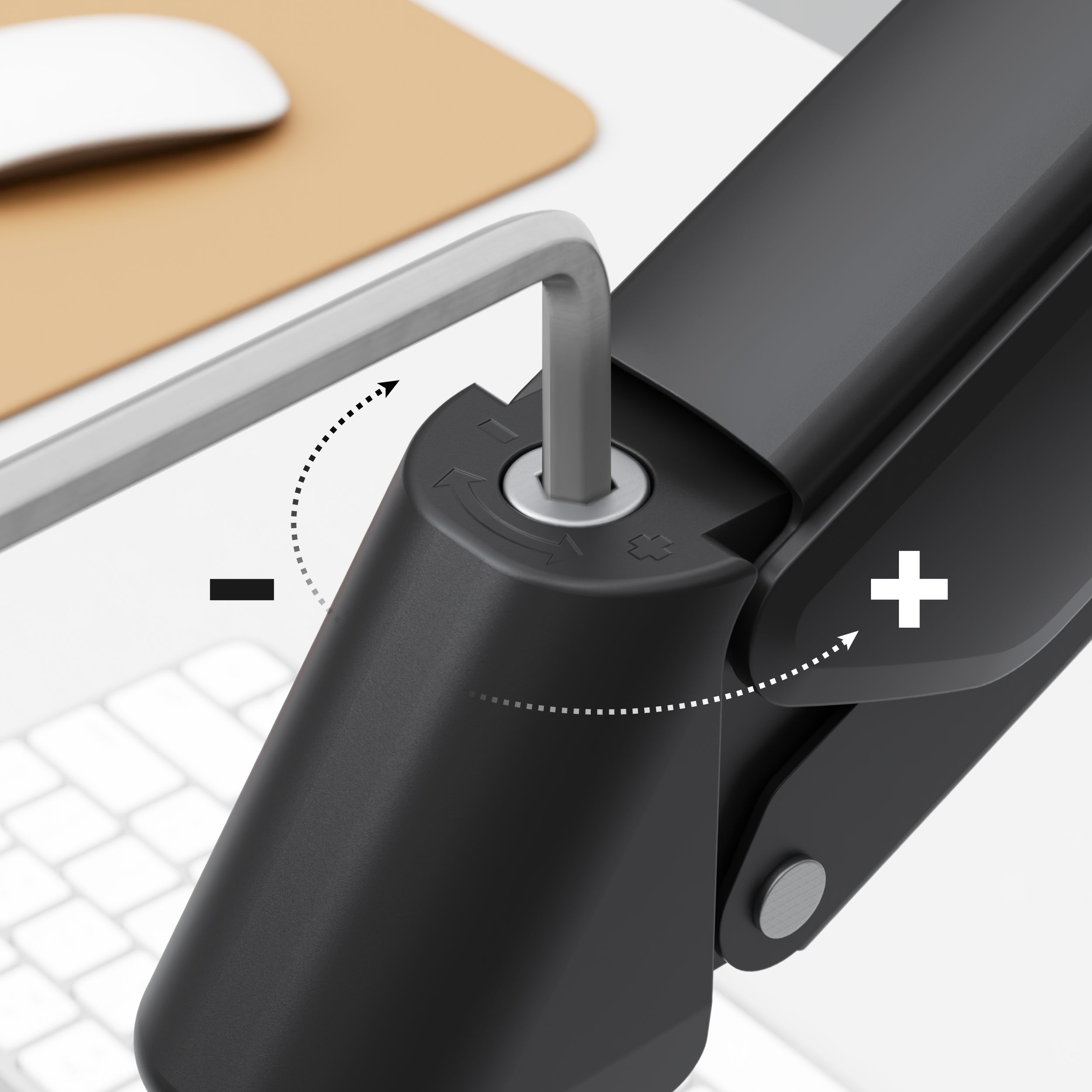 Un brazo de monitor negro con una llave hexagonal insertada, ajustando la tensión. Ratón y teclado blancos en el fondo.