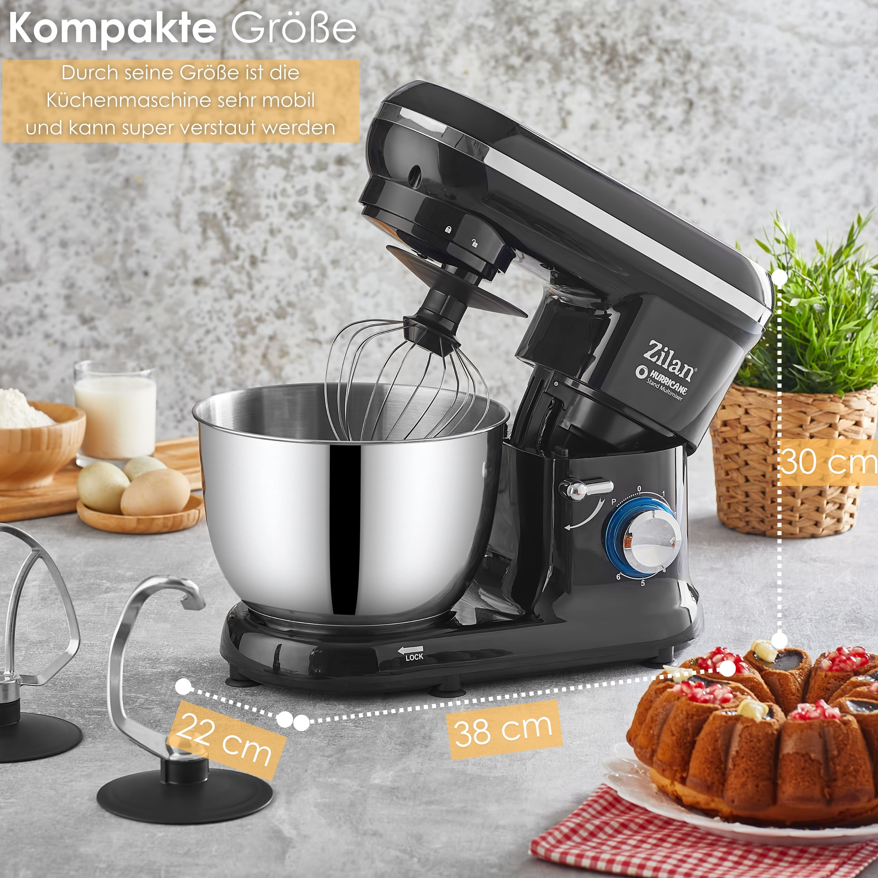 Schwarzer Küchenmixer mit Schüssel, Aufsätzen und Kuchen. Mehl, Eier und Milch links. Abmessungen sind angegeben.