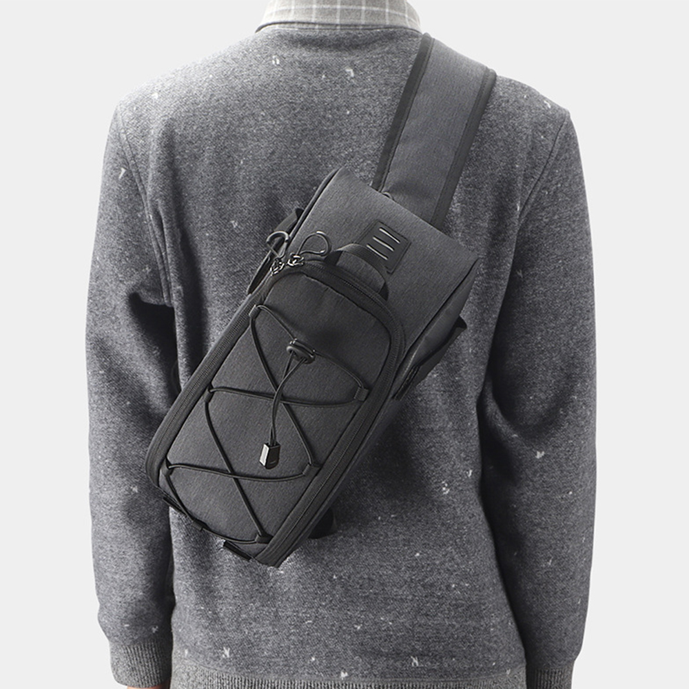 Eine Person von hinten mit grauem Pullover und schwarzer Umhängetasche. Die Tasche hat eine Vordertasche und einen Riemen.