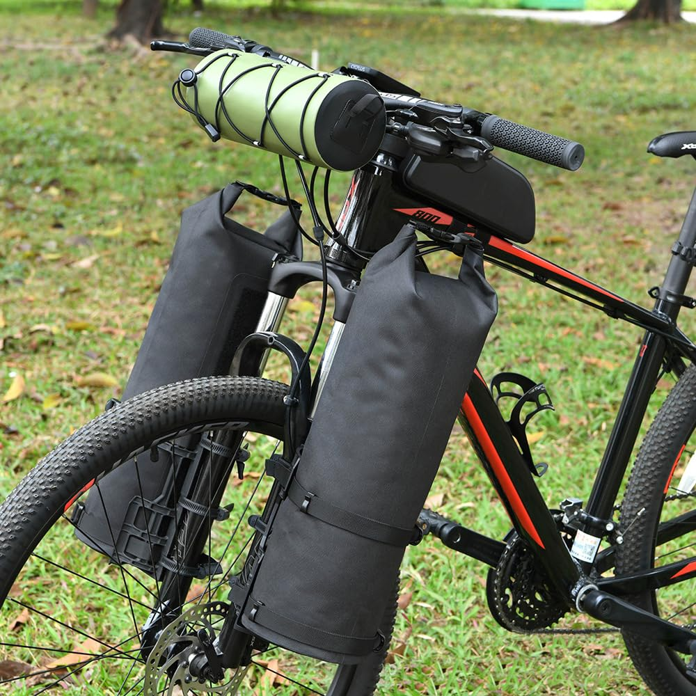 Schwarzes Mountainbike mit grüner Lenkertasche und schwarzen Seitentaschen. Gras im Hintergrund. Roter und schwarzer Rahmen.