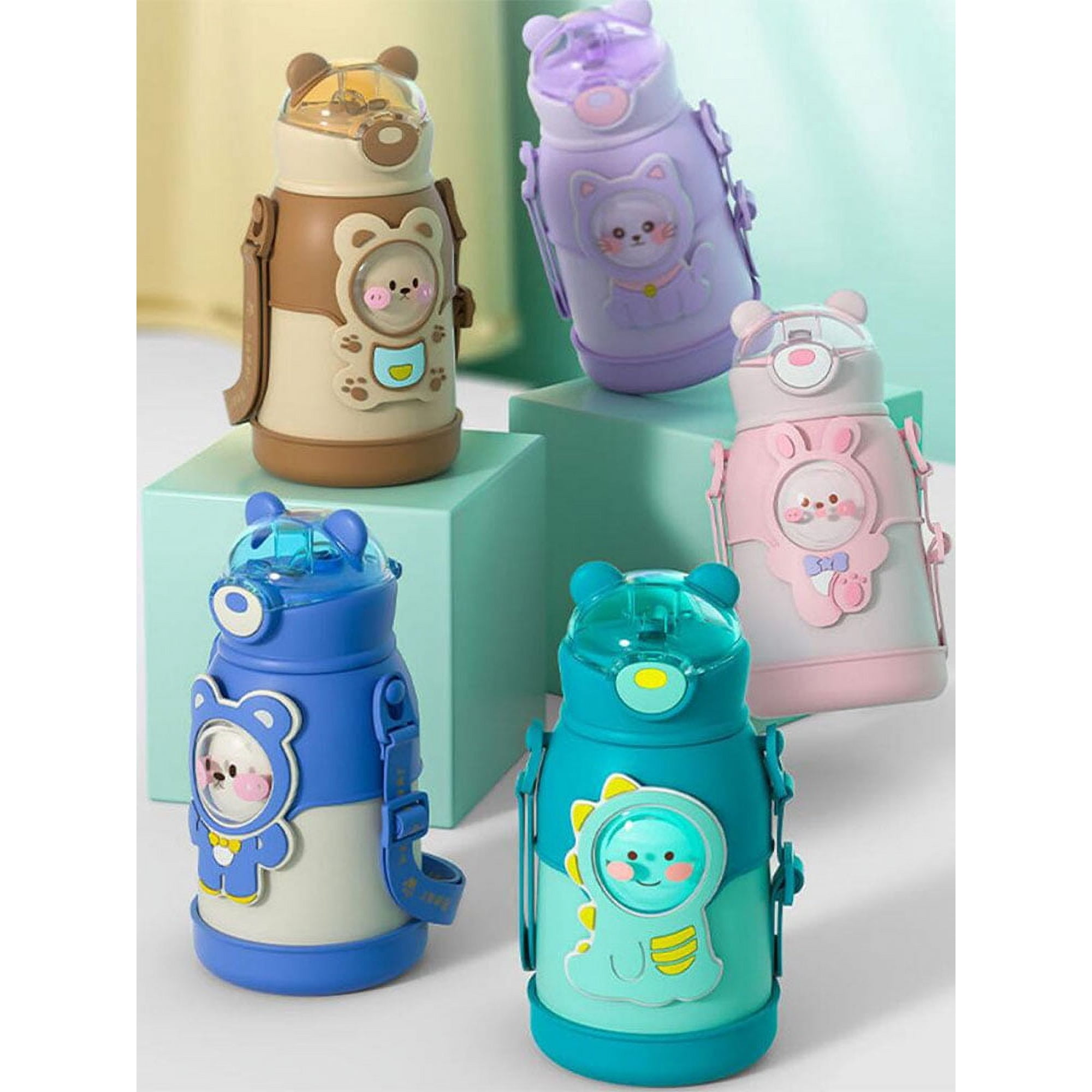 Fünf bunte Wasserflaschen mit Tierdesigns wie Bären und Katzen. Sie stehen auf grünen und blauen Blöcken.