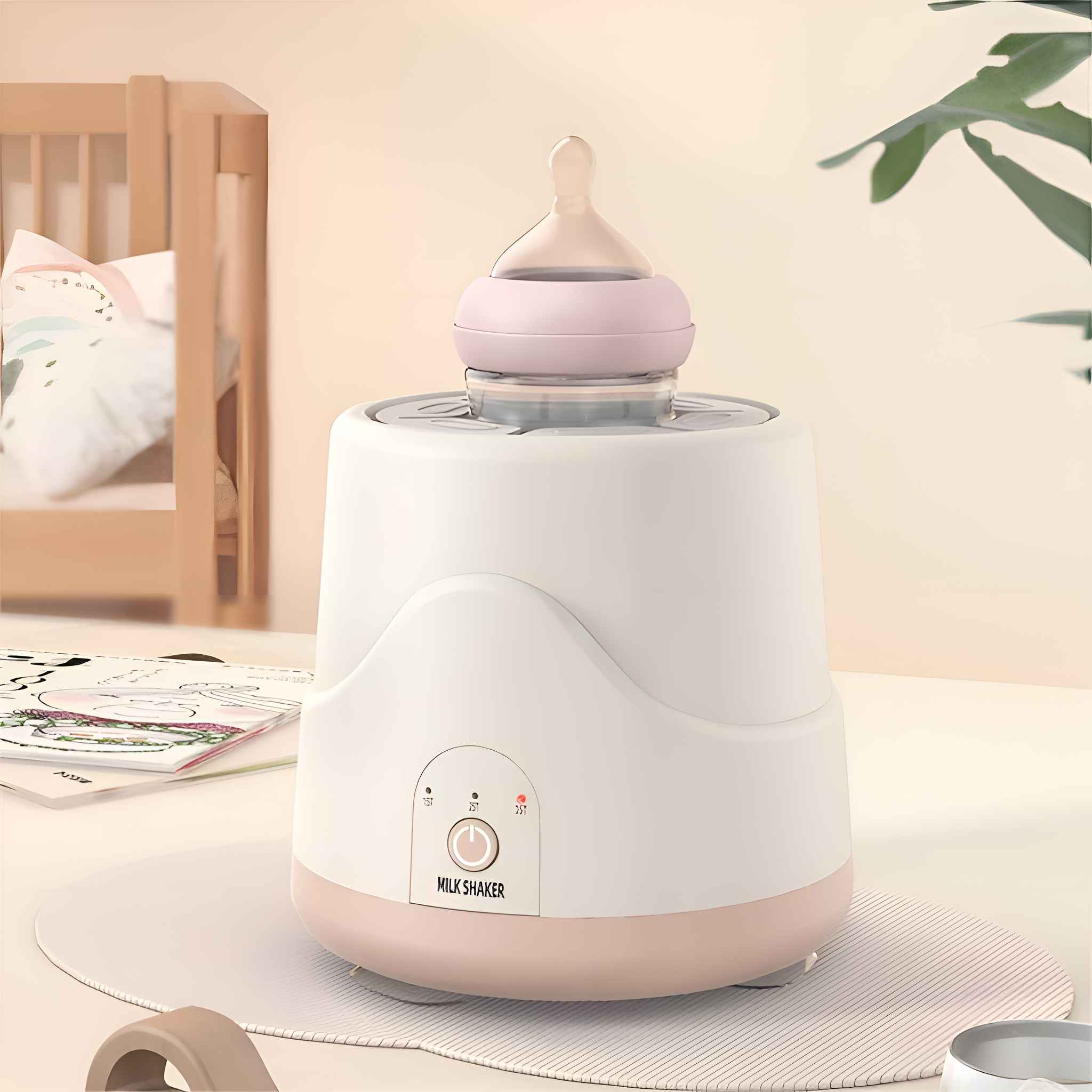 Ein weiß-rosa Milchschüttler mit einer Flasche. Im Hintergrund sind ein Kinderbett und eine Pflanze. Der Schüttler steht auf einer Matte.