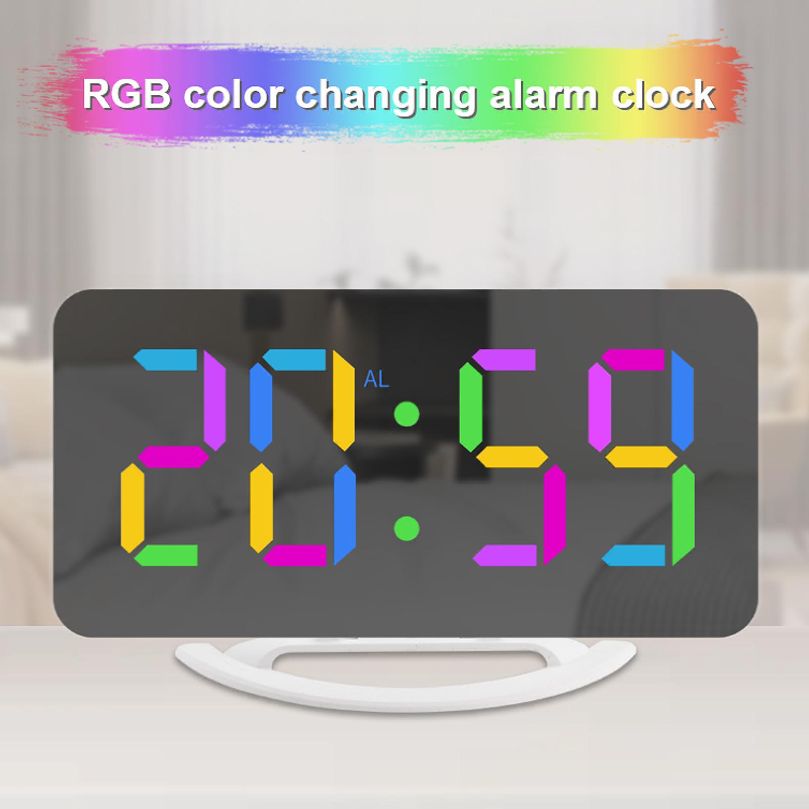 Ein RGB-Farbwechsel-Wecker zeigt 20:59 in bunten, segmentierten Ziffern an. Die Uhr steht auf einem weißen Ständer.