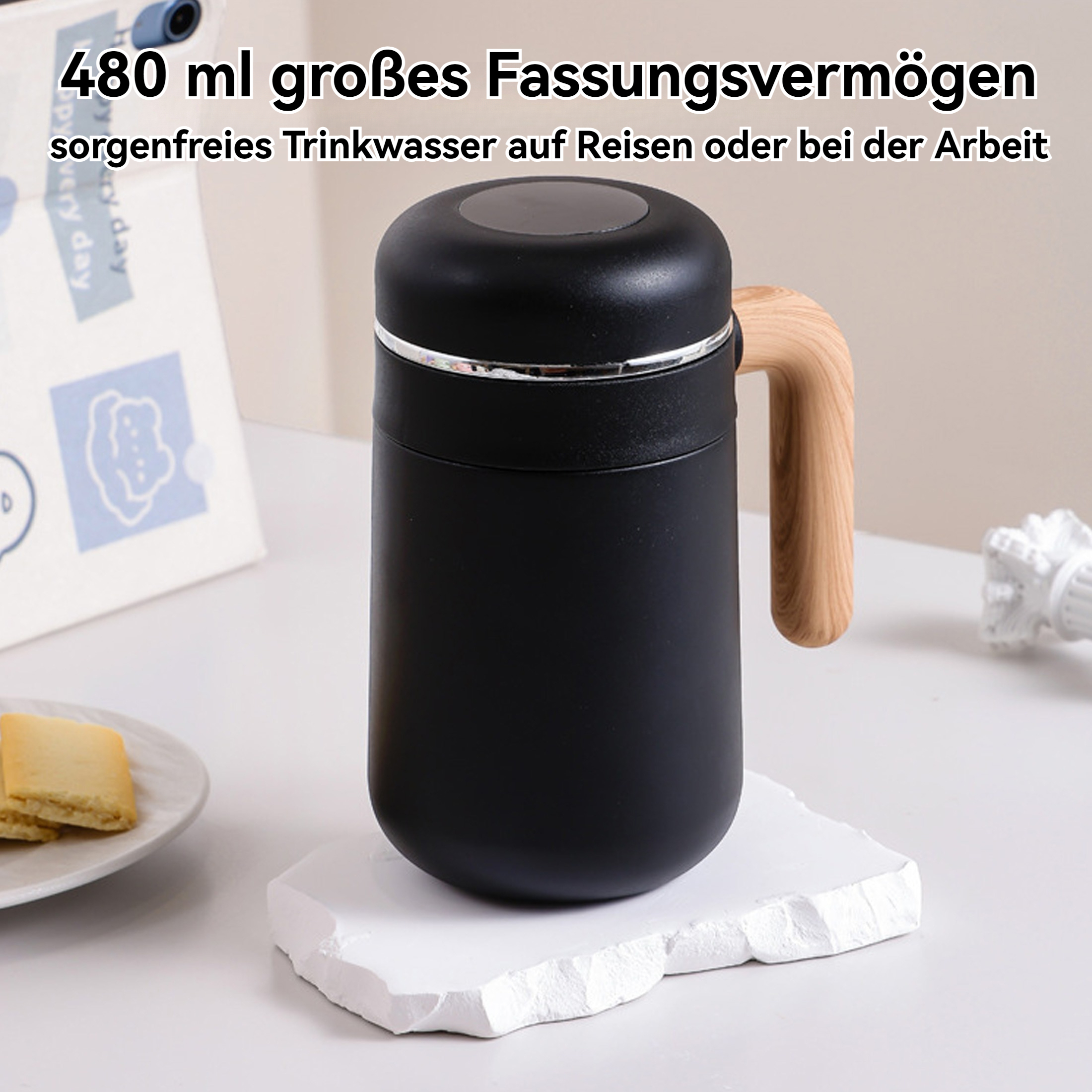 Eine schwarze Thermoskanne mit Holzgriff steht auf einem weißen Stein. Im Hintergrund ein Teller mit Keksen.